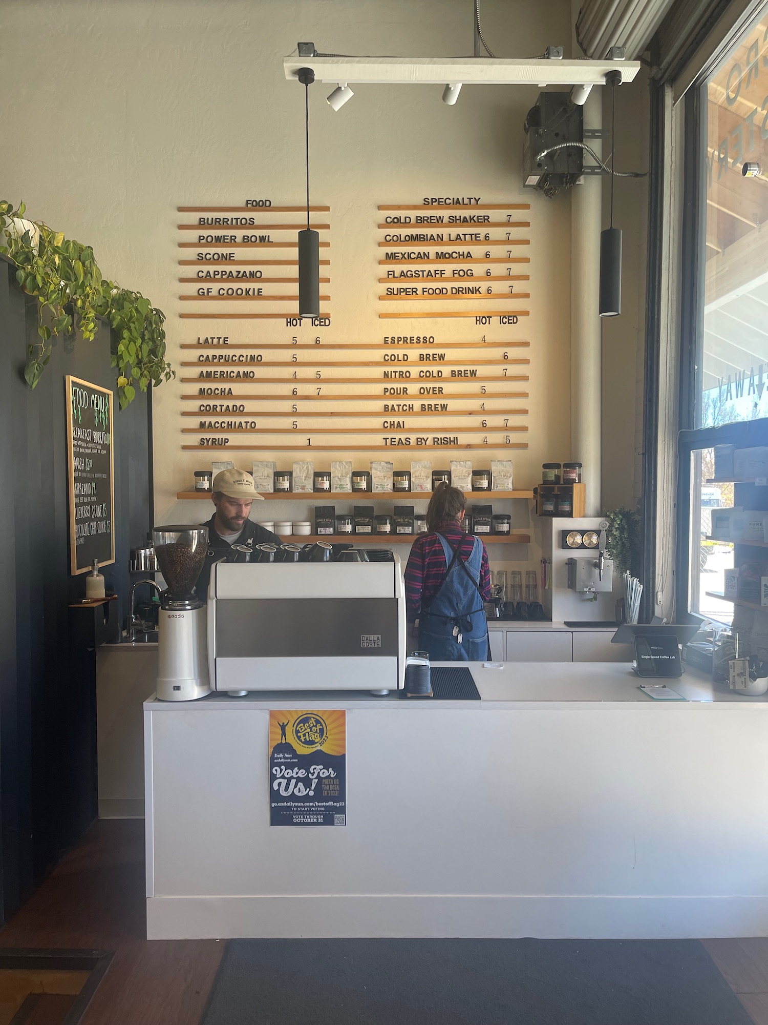 a man and woman standing behind a counter in a coffee shop