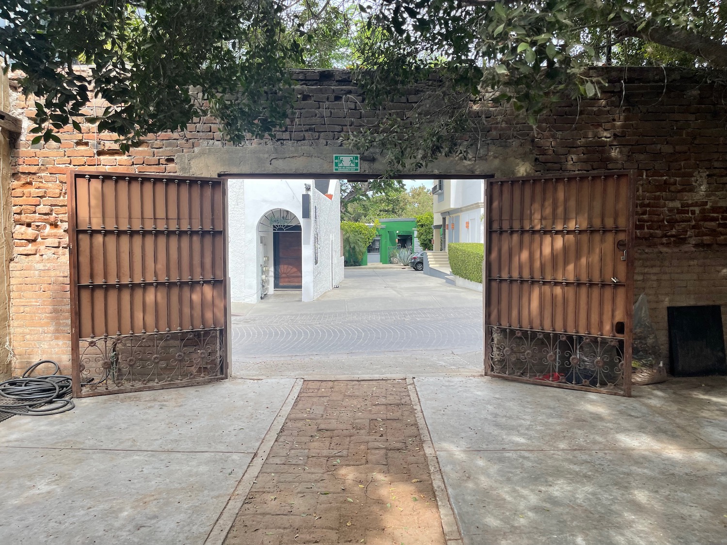 a gate with trees and a street in the background