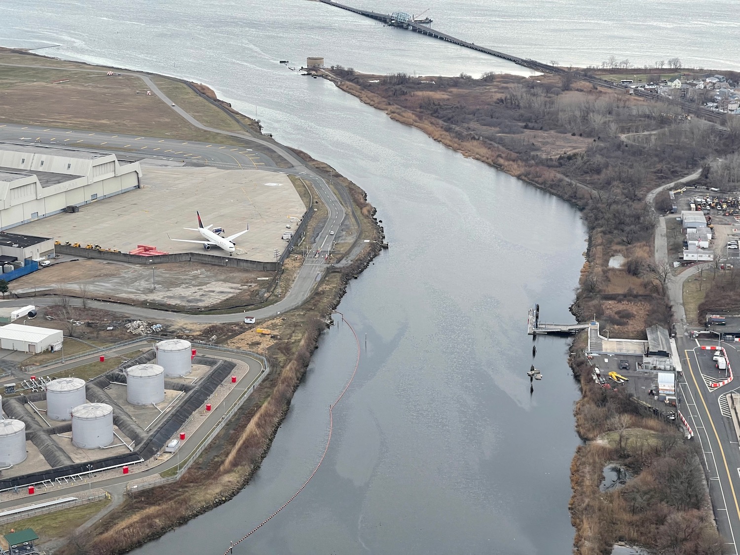 a river with a runway and buildings and a bridge