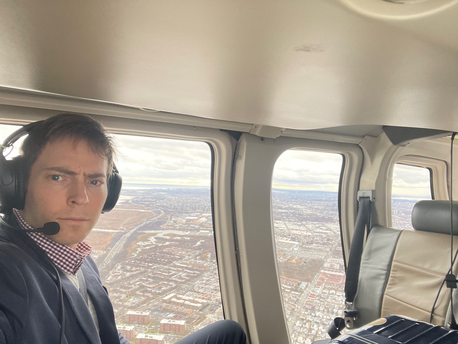 a man in a suit and headphones sitting in a helicopter