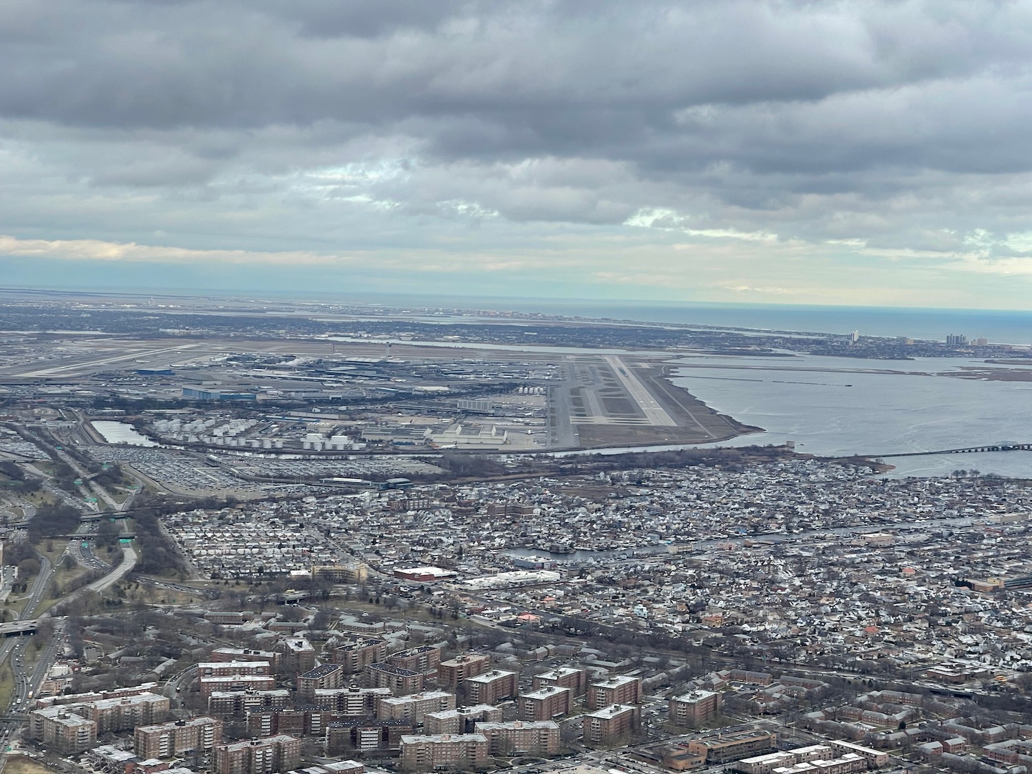 an aerial view of a city with a runway and water