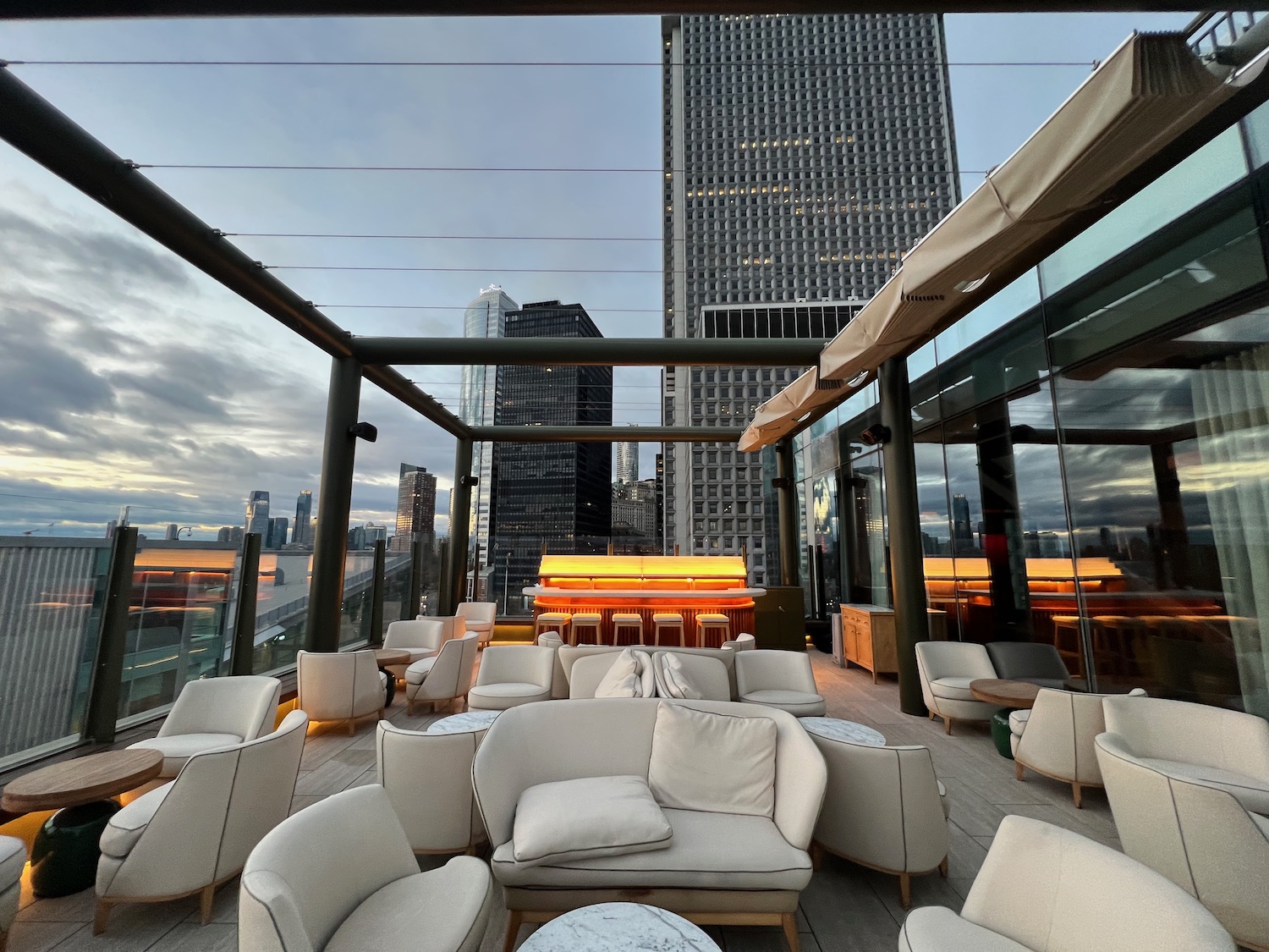 a rooftop patio with a large glass building and a tall skyscraper