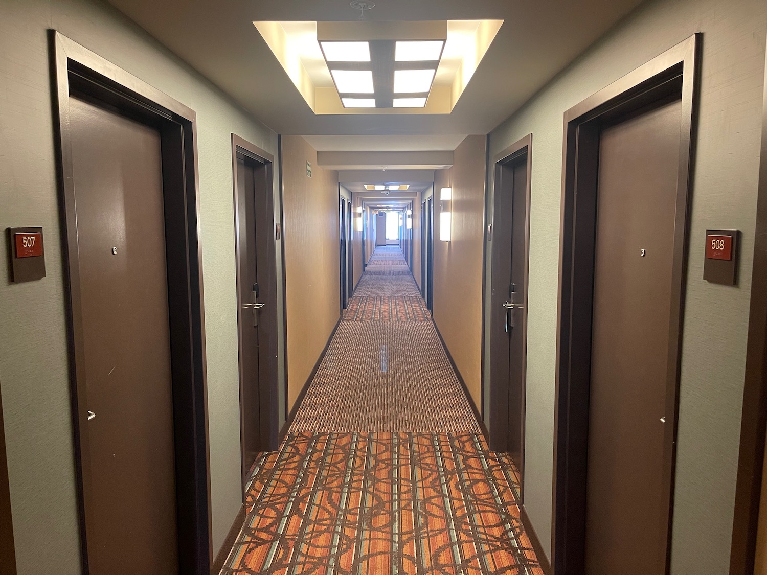 a hallway with brown doors and brown carpet