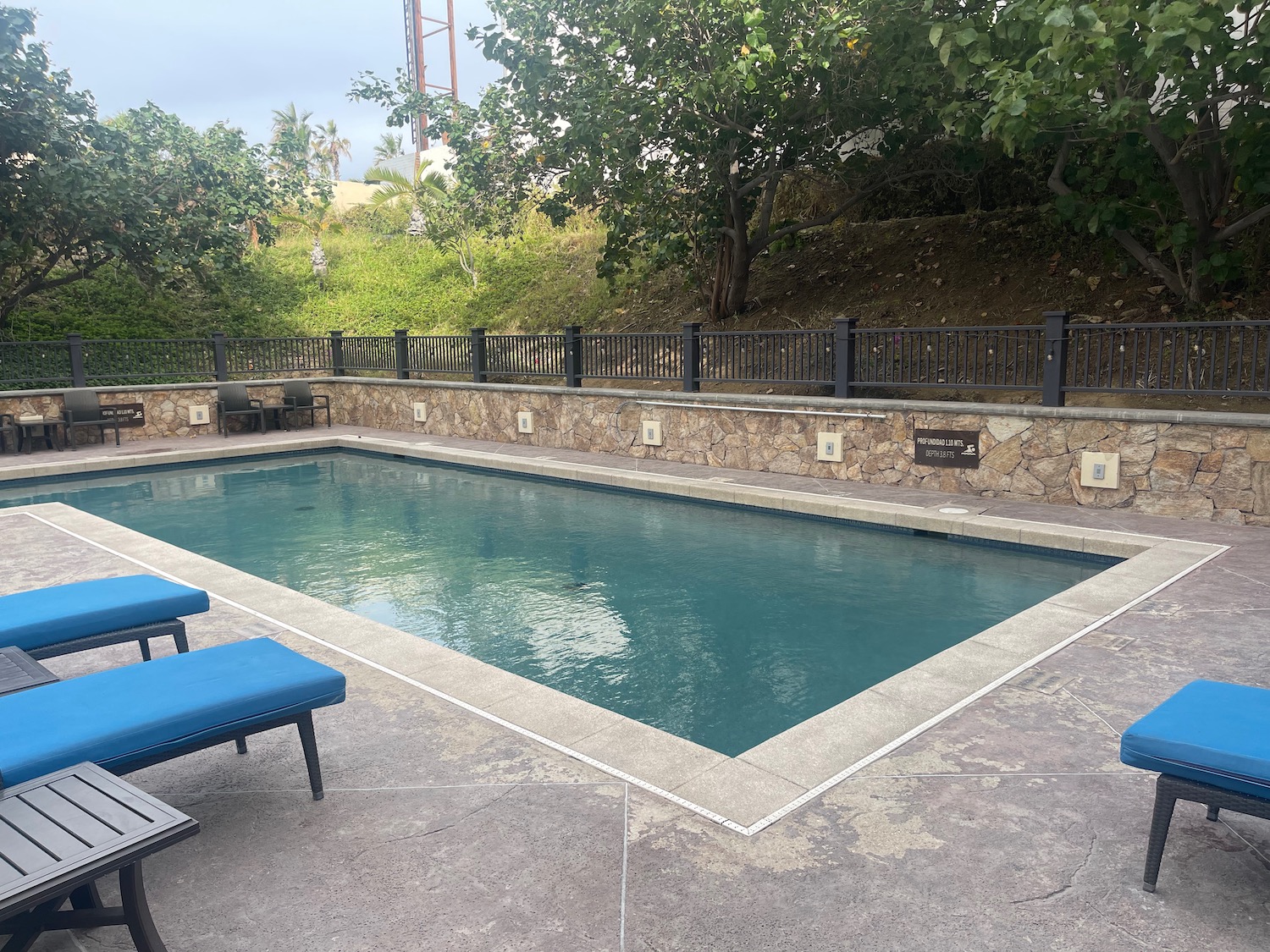 a pool with chairs and a fence