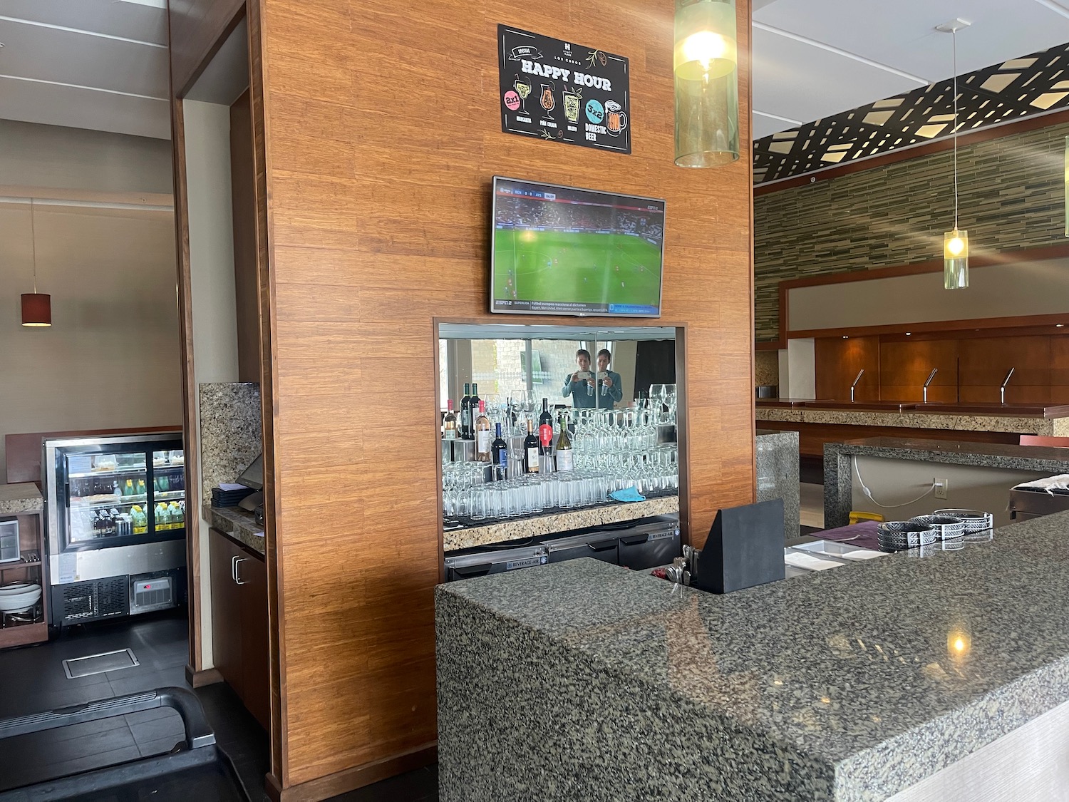 a bar with a television and drinks on the wall