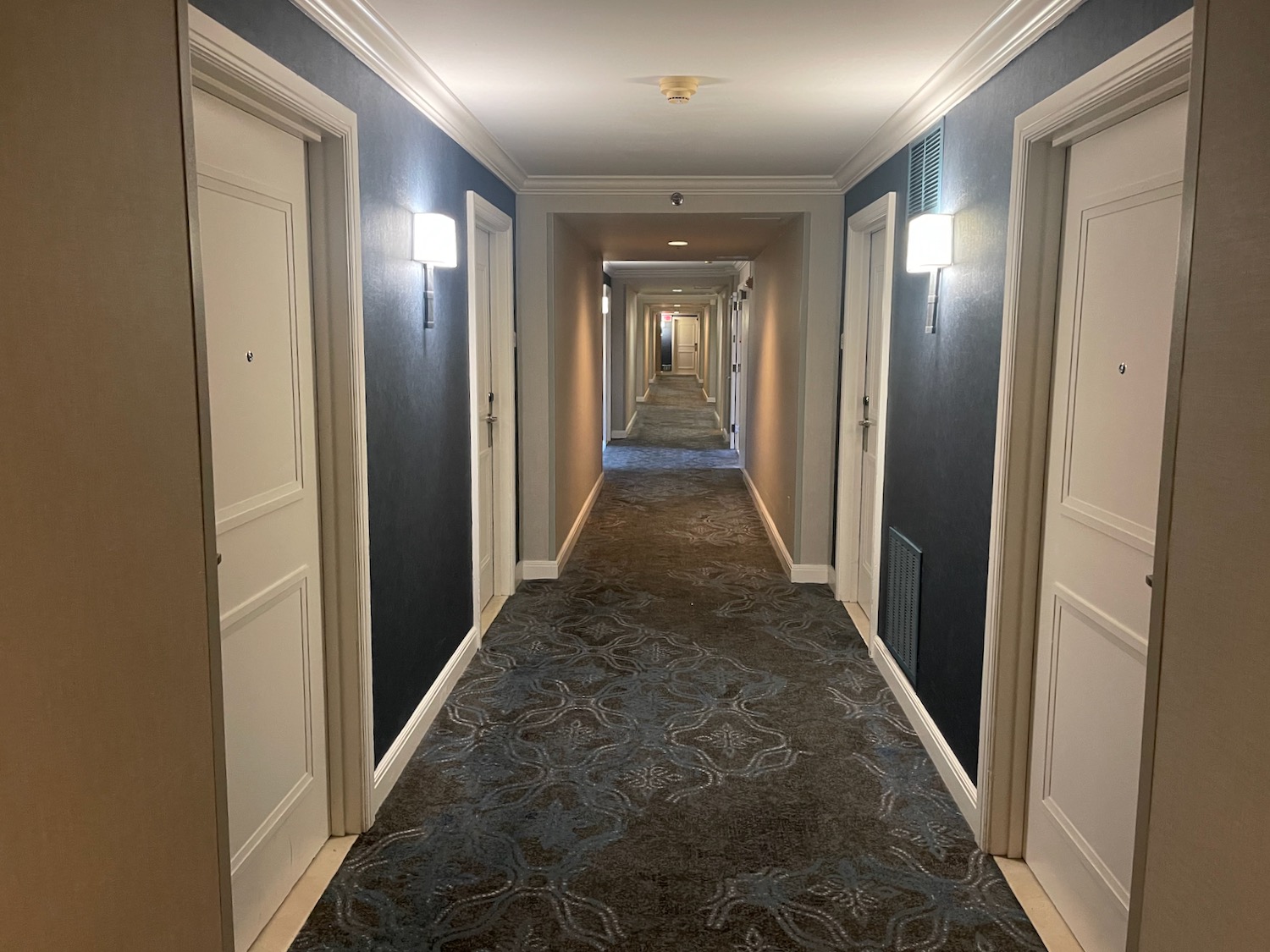 a hallway with doors and a patterned carpet