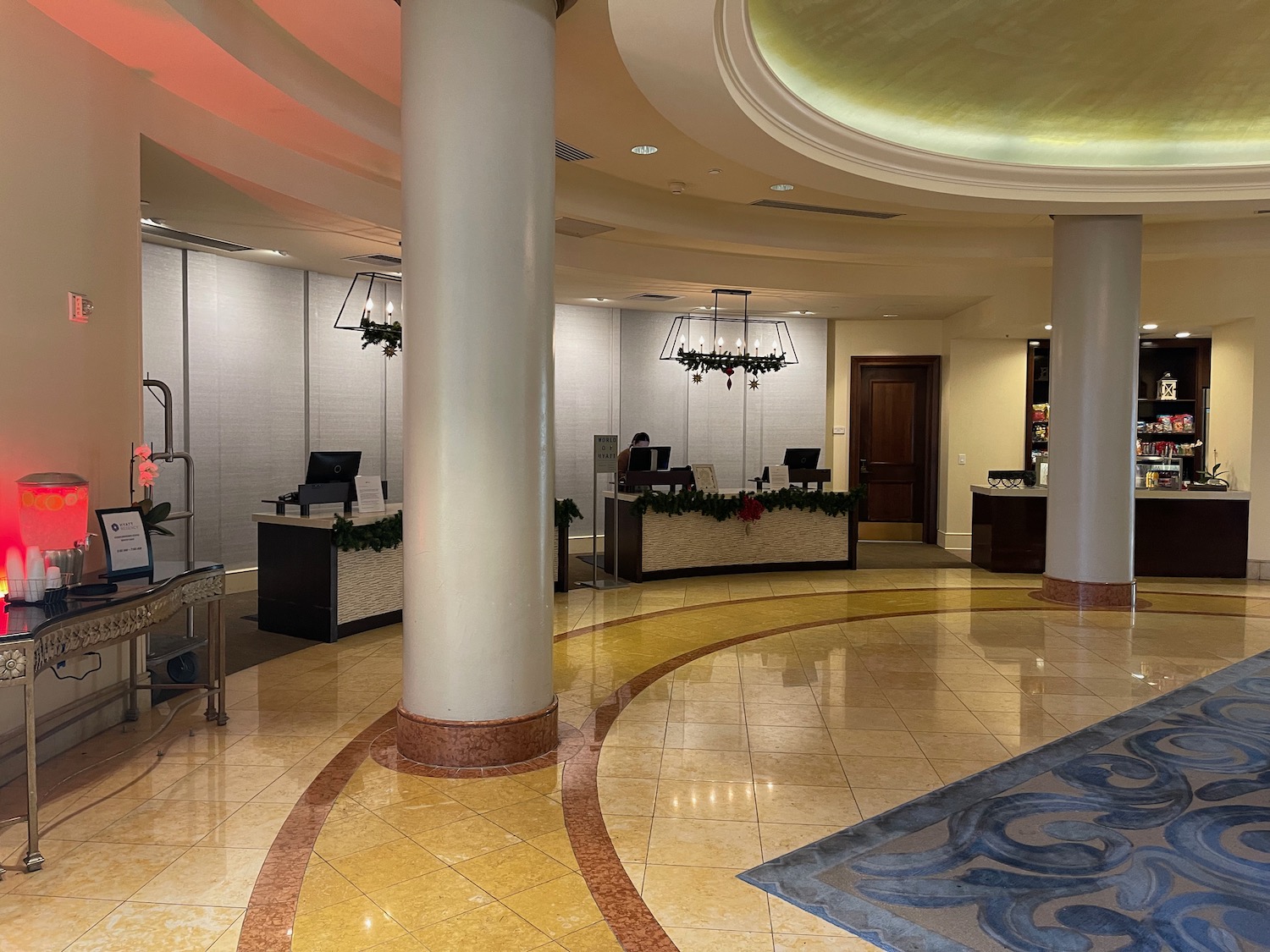 a lobby with a large white column and a large chandelier