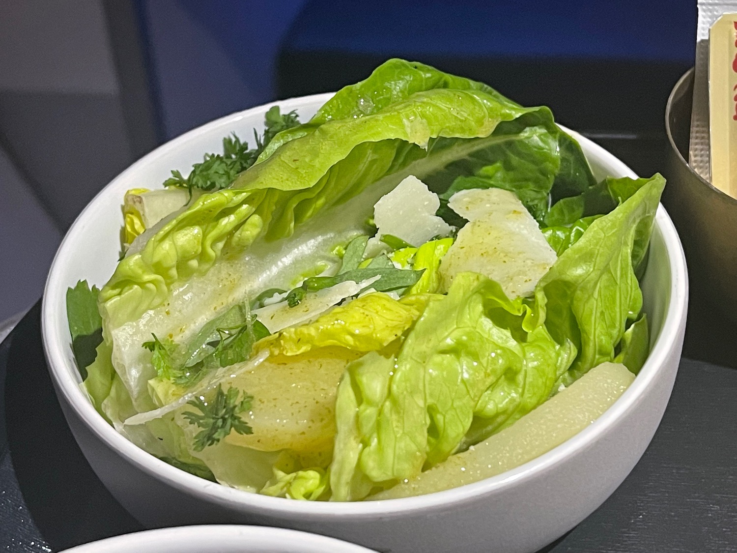 a bowl of salad with lettuce and parmesan