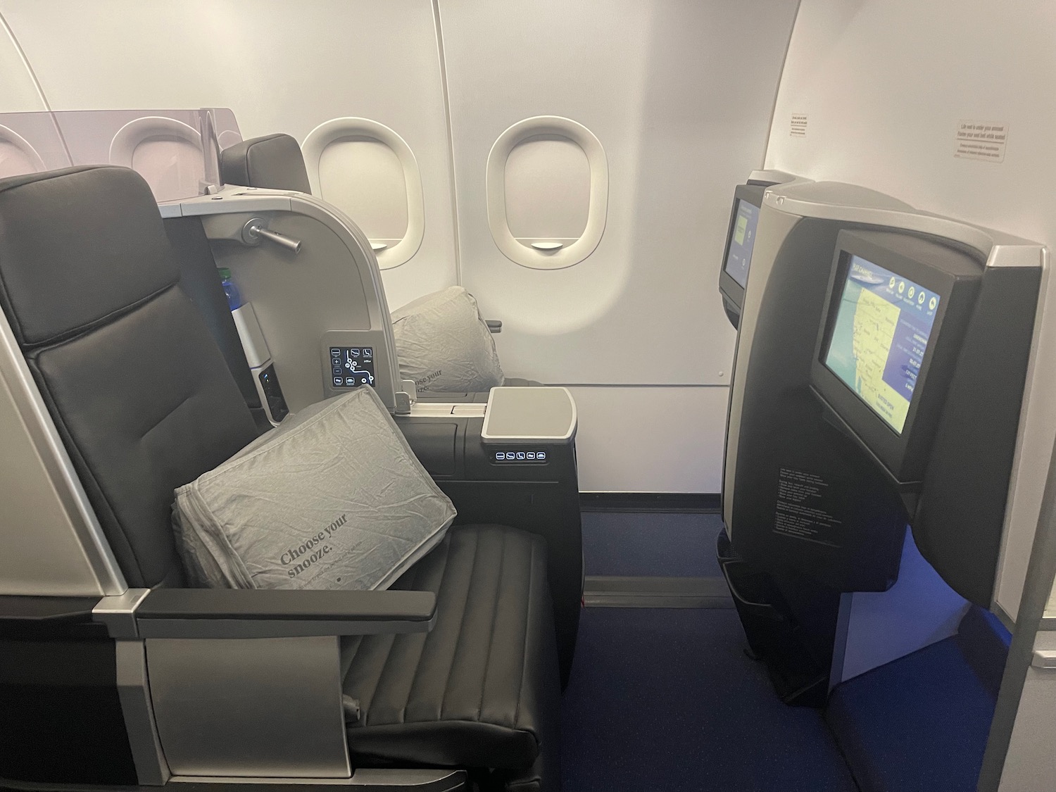 a seat and a monitor in an airplane