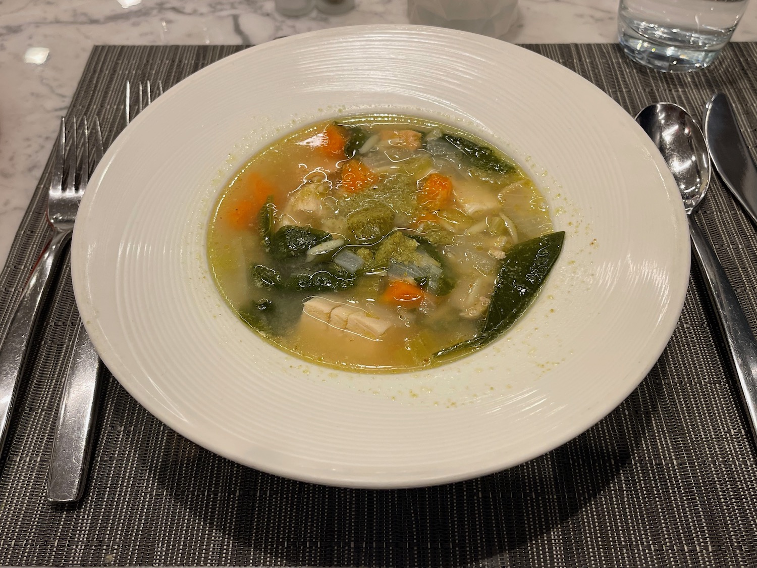 a bowl of soup with vegetables and a spoon