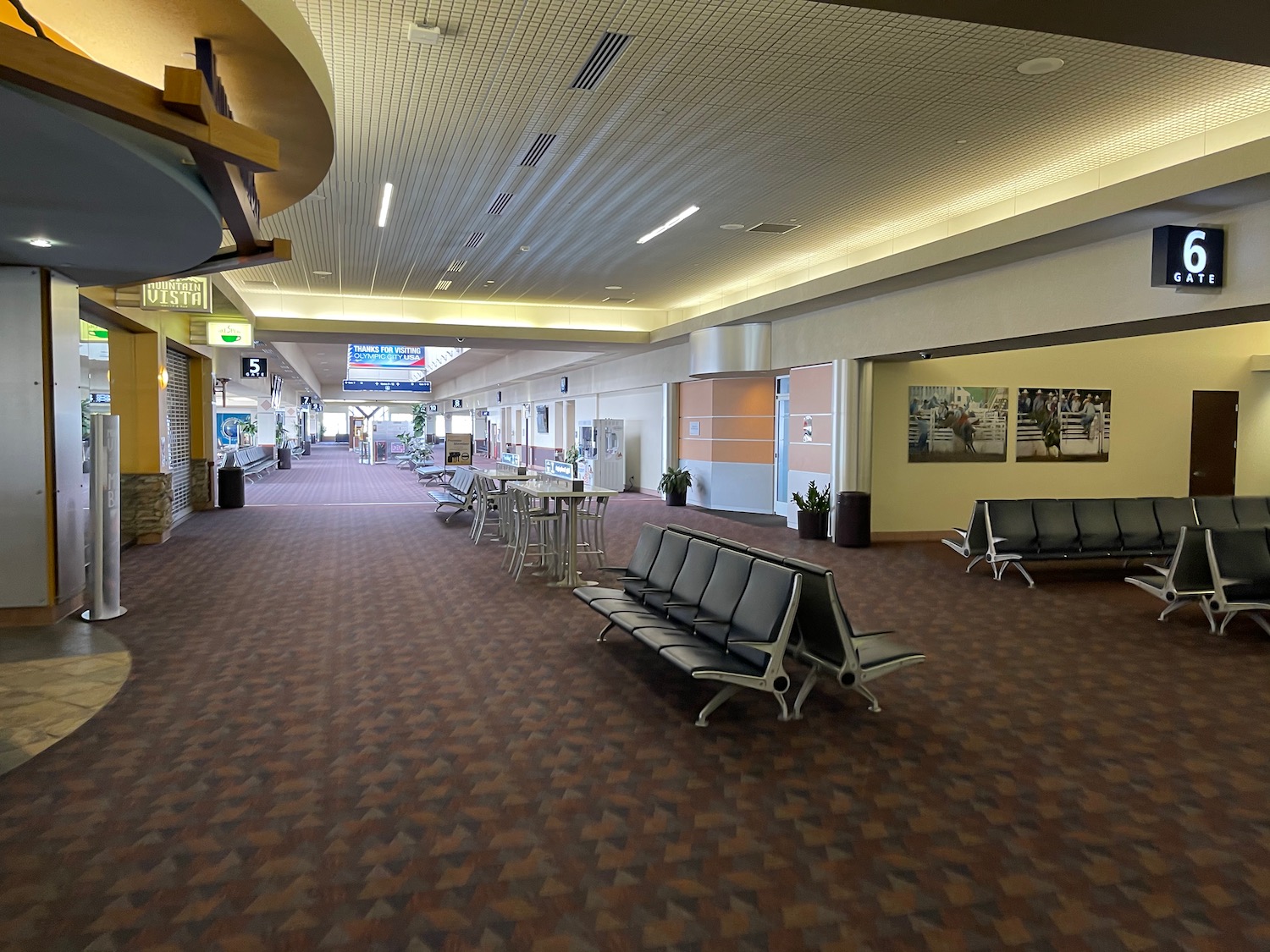 a empty airport terminal with chairs and tables