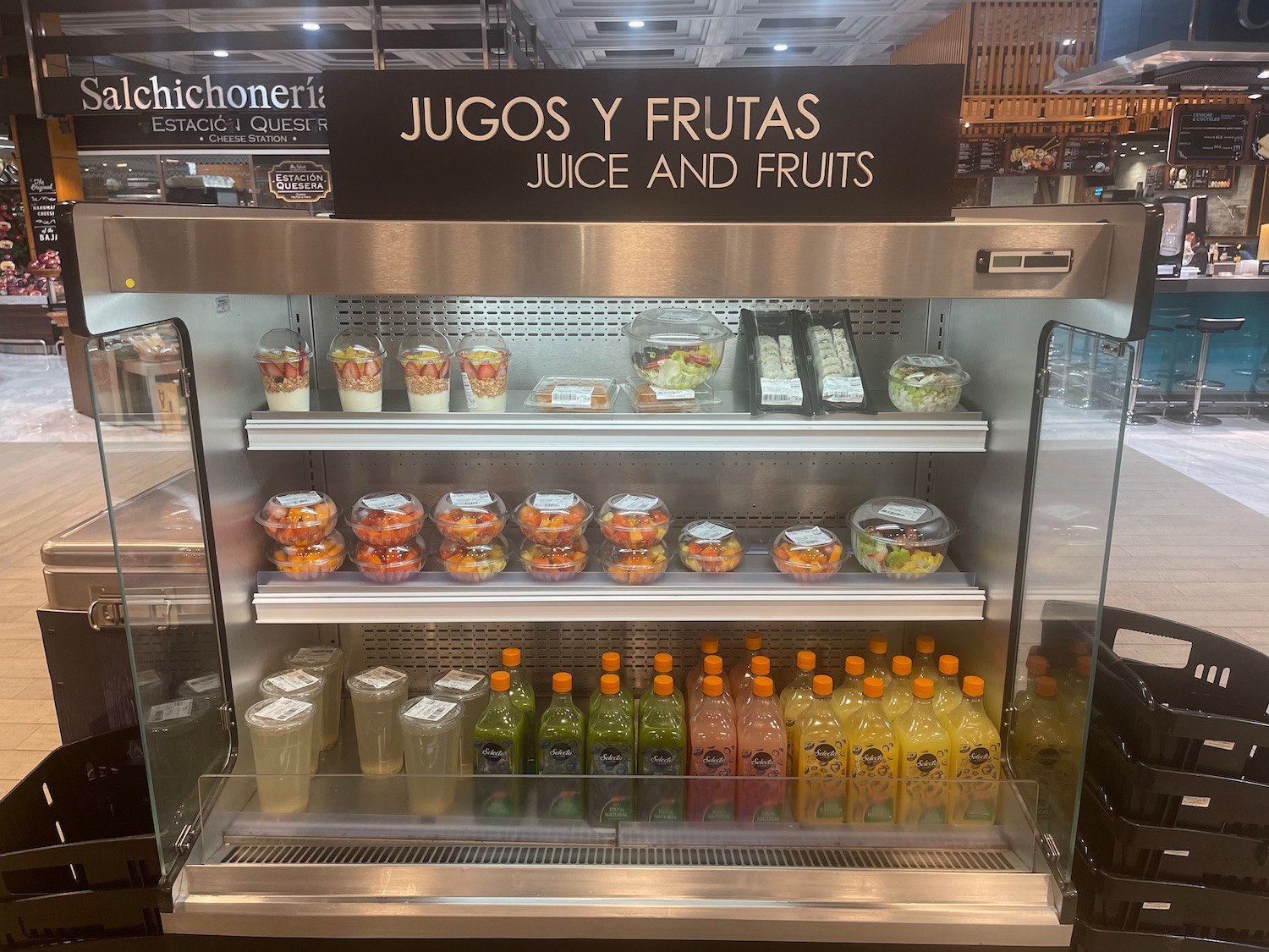 a display case with drinks and fruit in it
