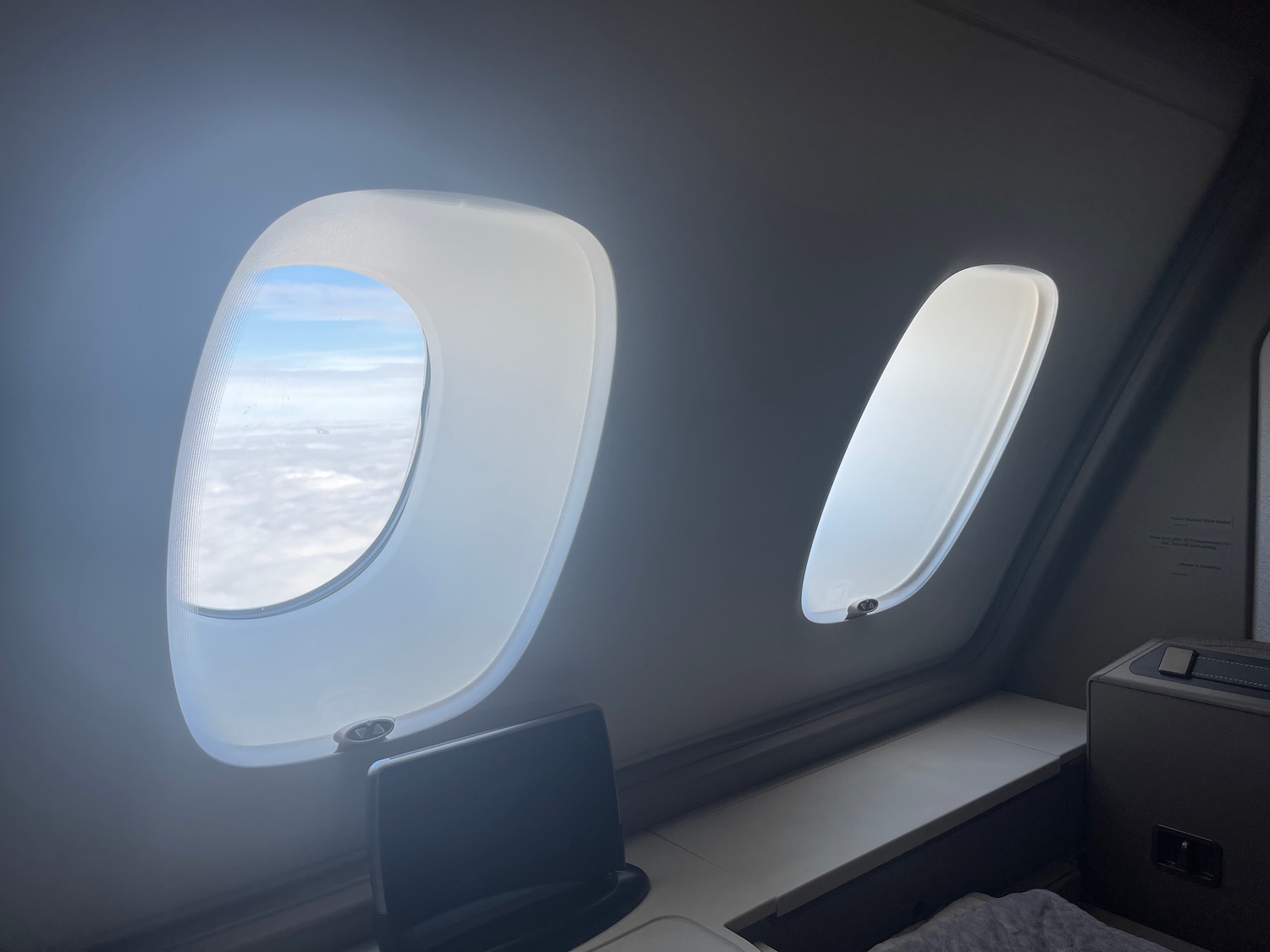 a window with a view of clouds and a bed