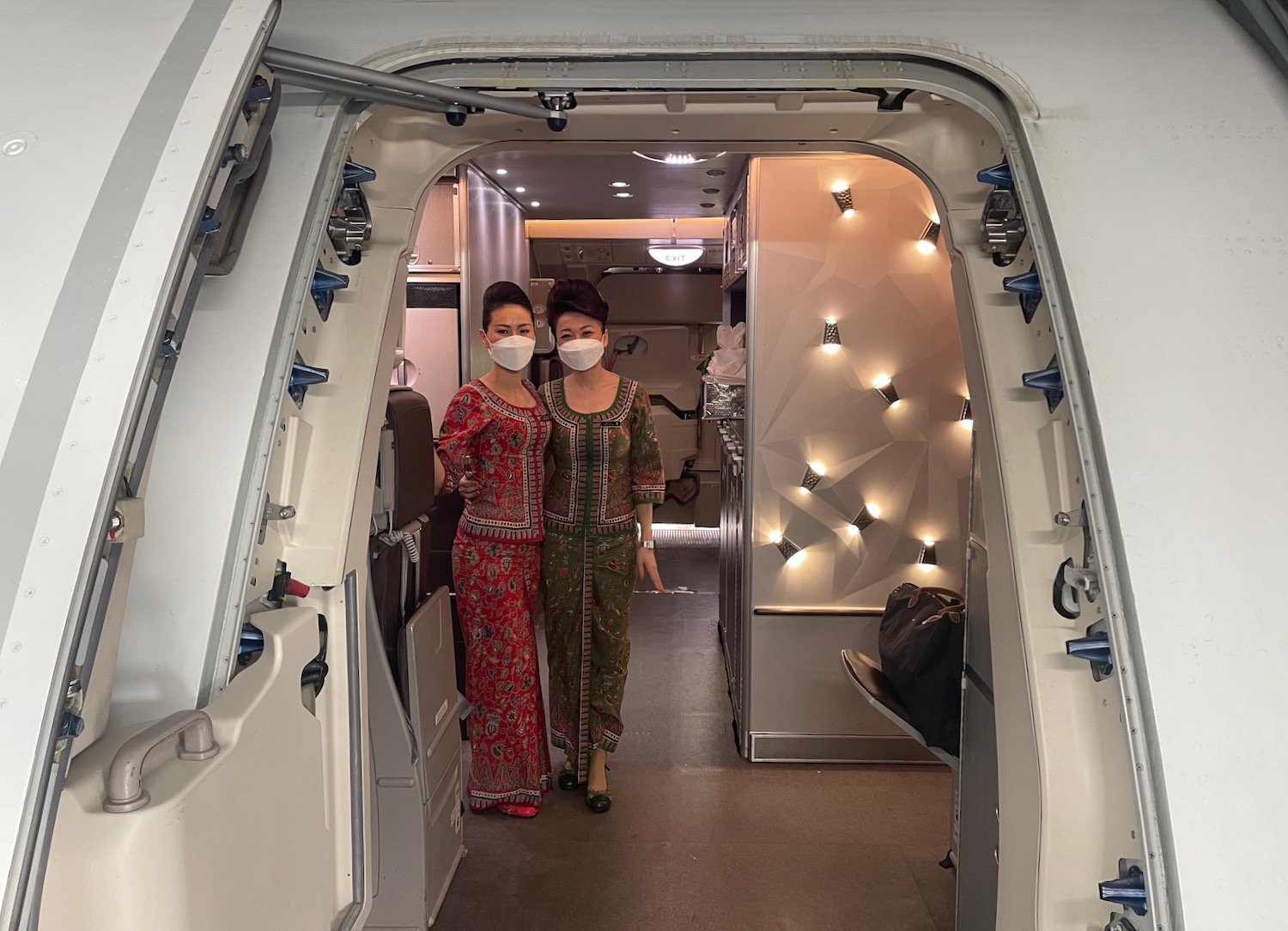 two women wearing masks in an airplane