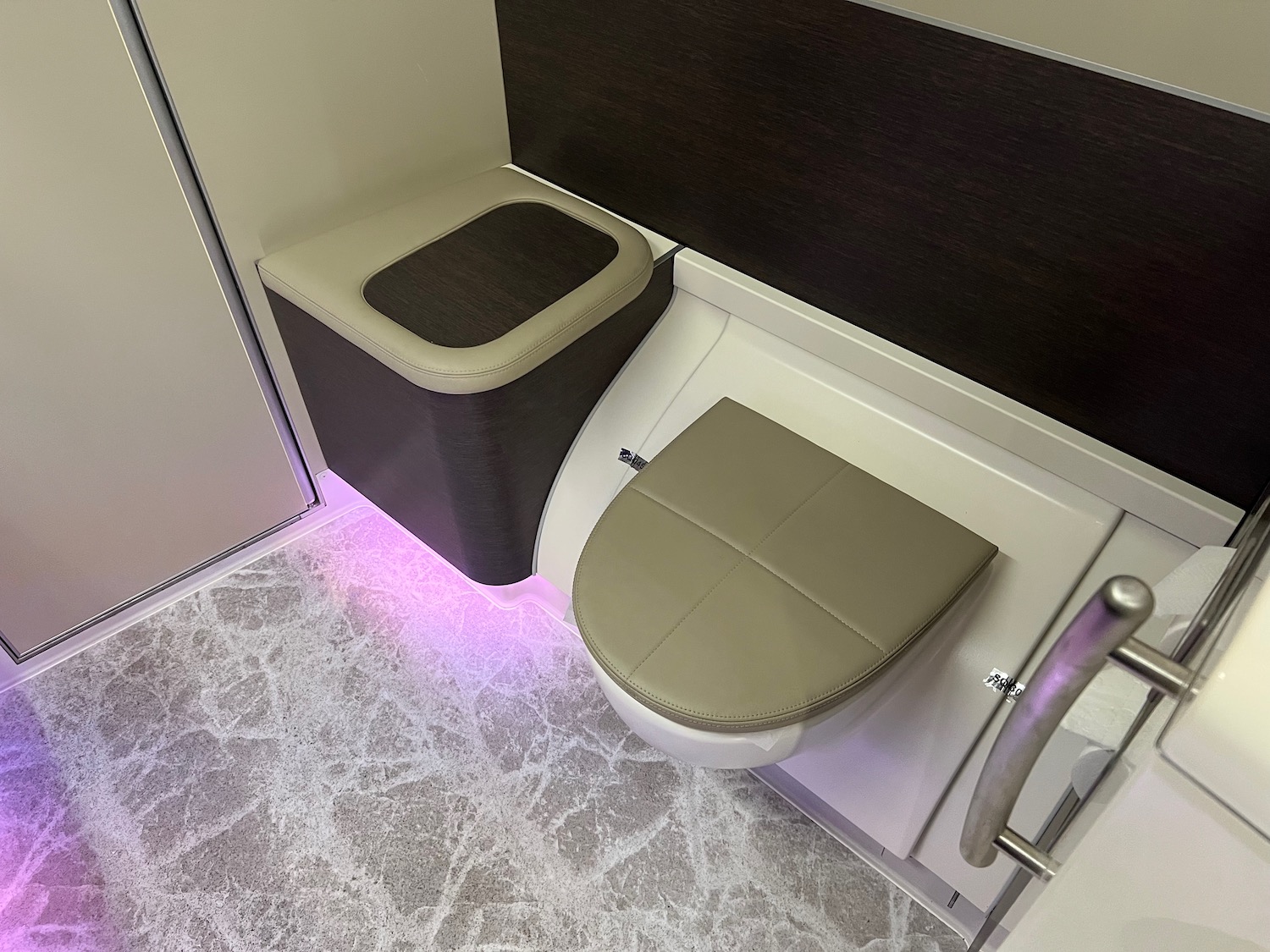 a toilet with a light purple light