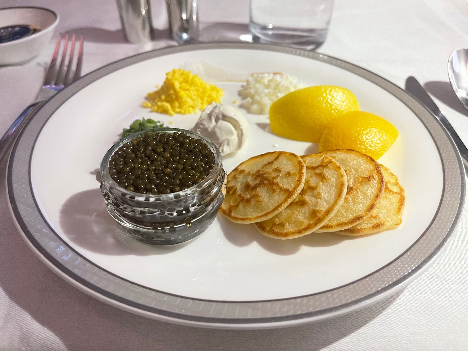 a plate of food with lemons and black caviar