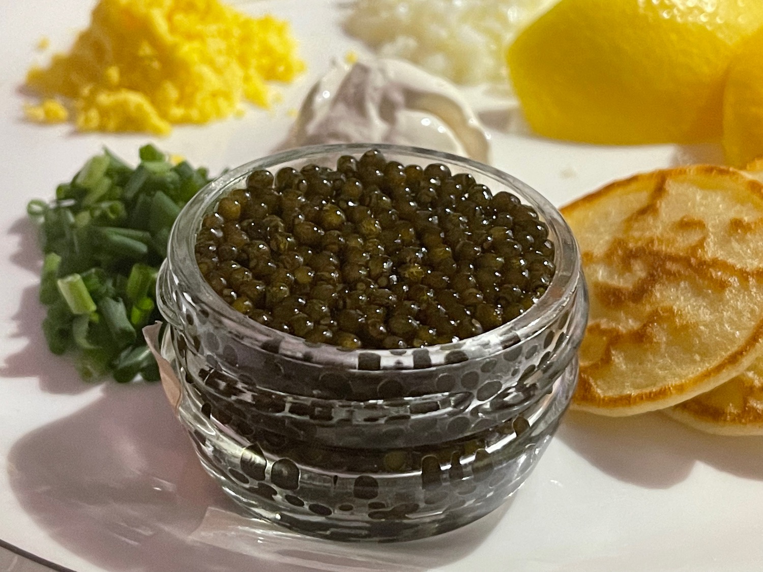 a jar of black caviar on a plate