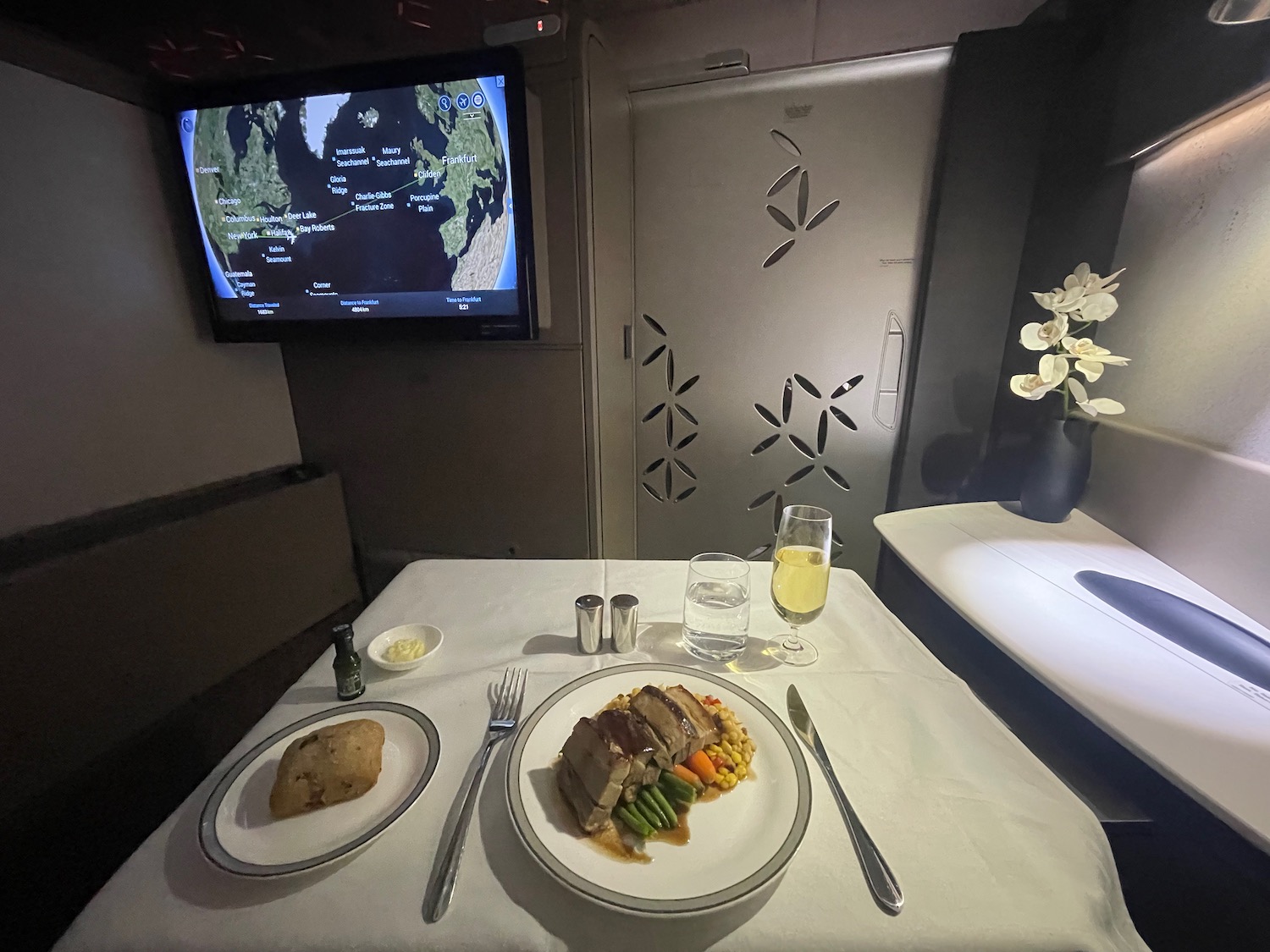 a plate of food on a table with a television on the wall