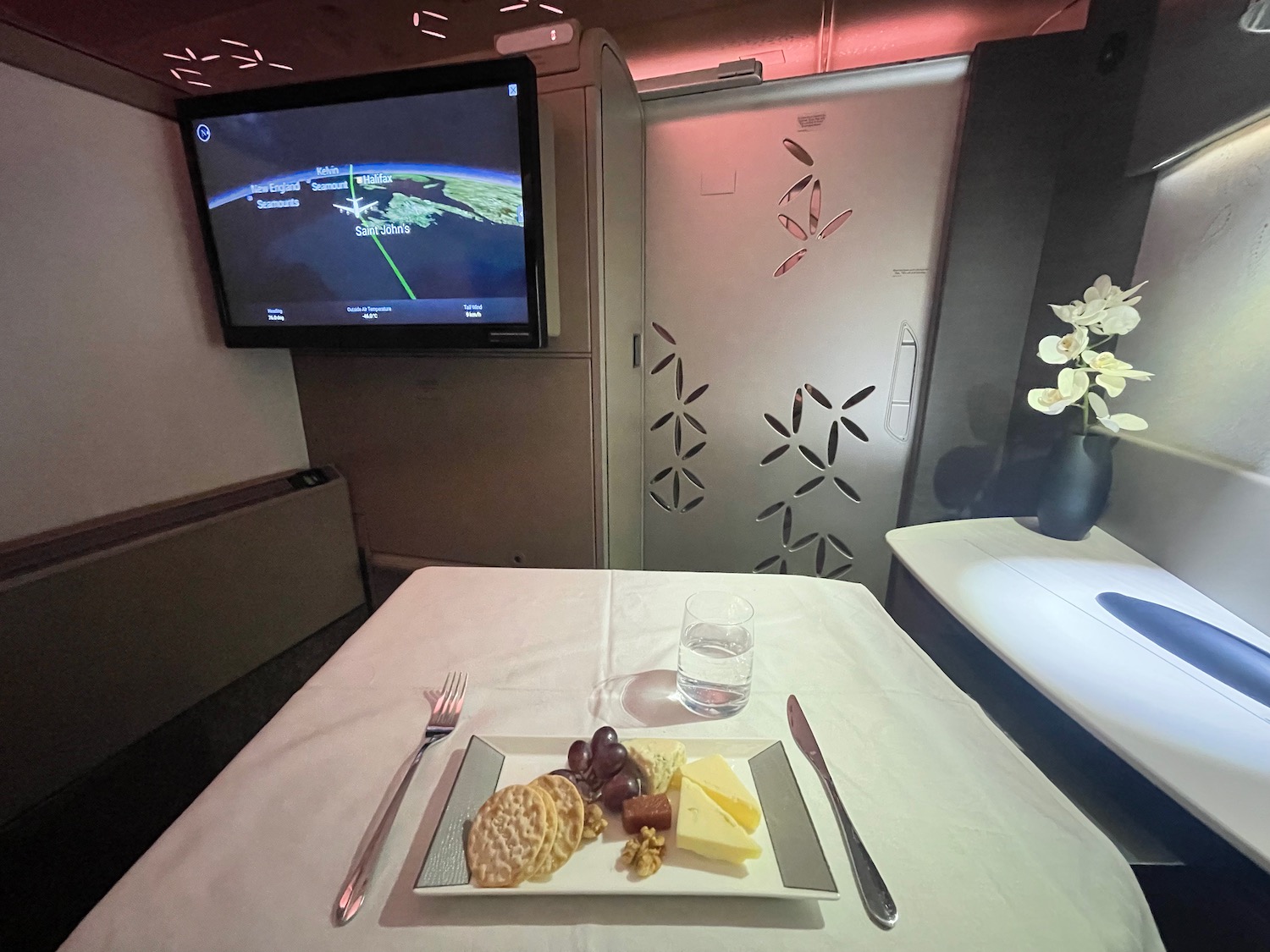 a plate of food on a table with a television in the background