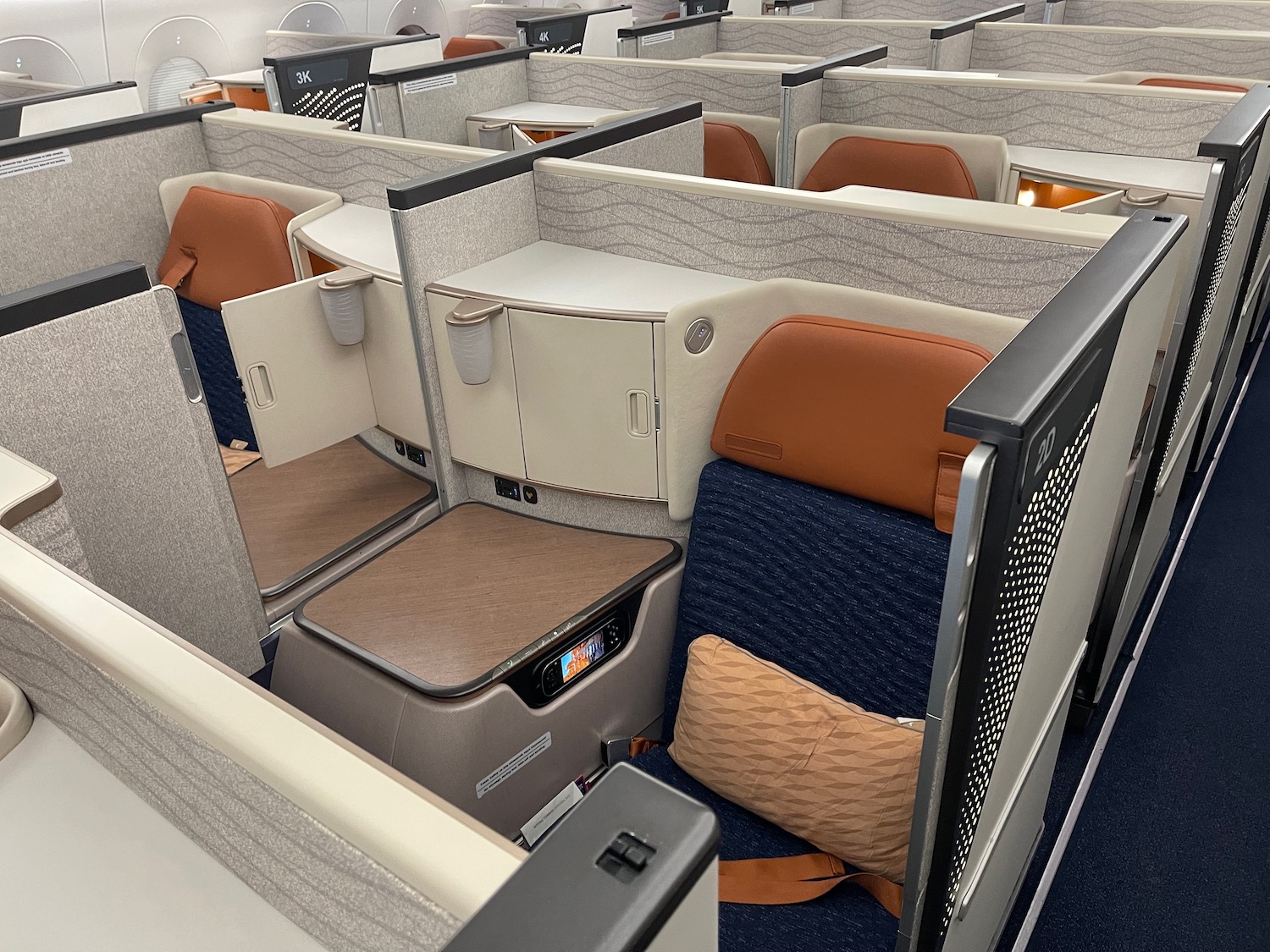 an airplane cabin with cubicles and chairs