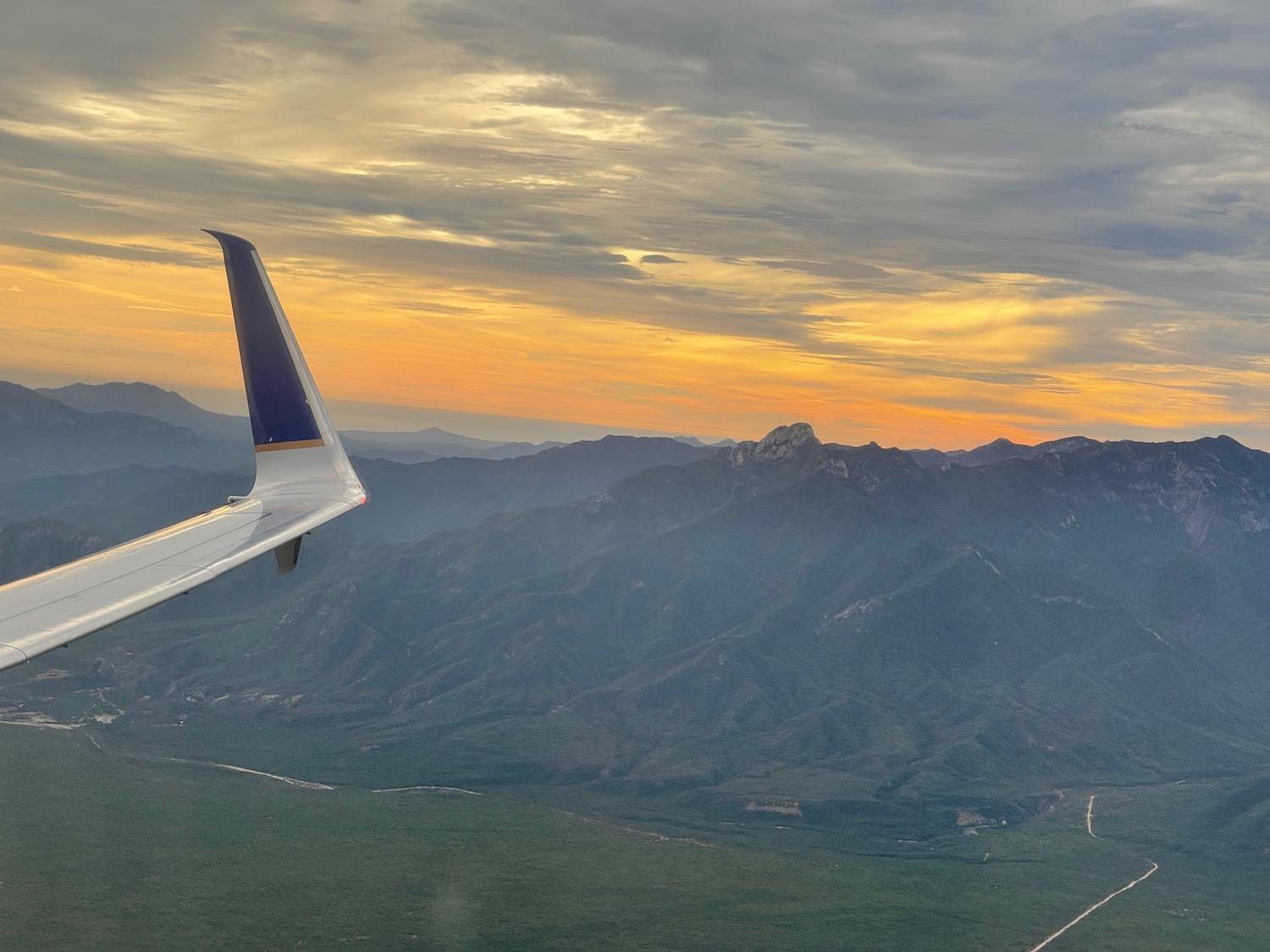 an airplane wing over a valley