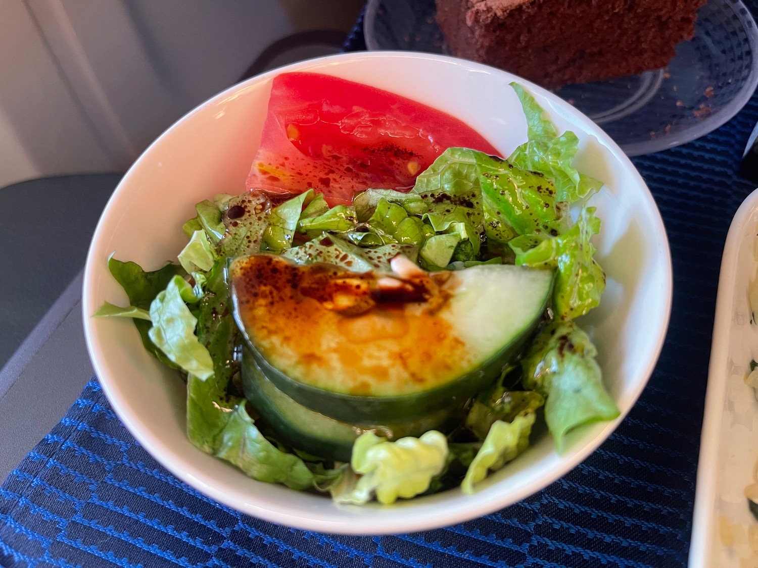 a bowl of salad with a slice of cucumber and tomato