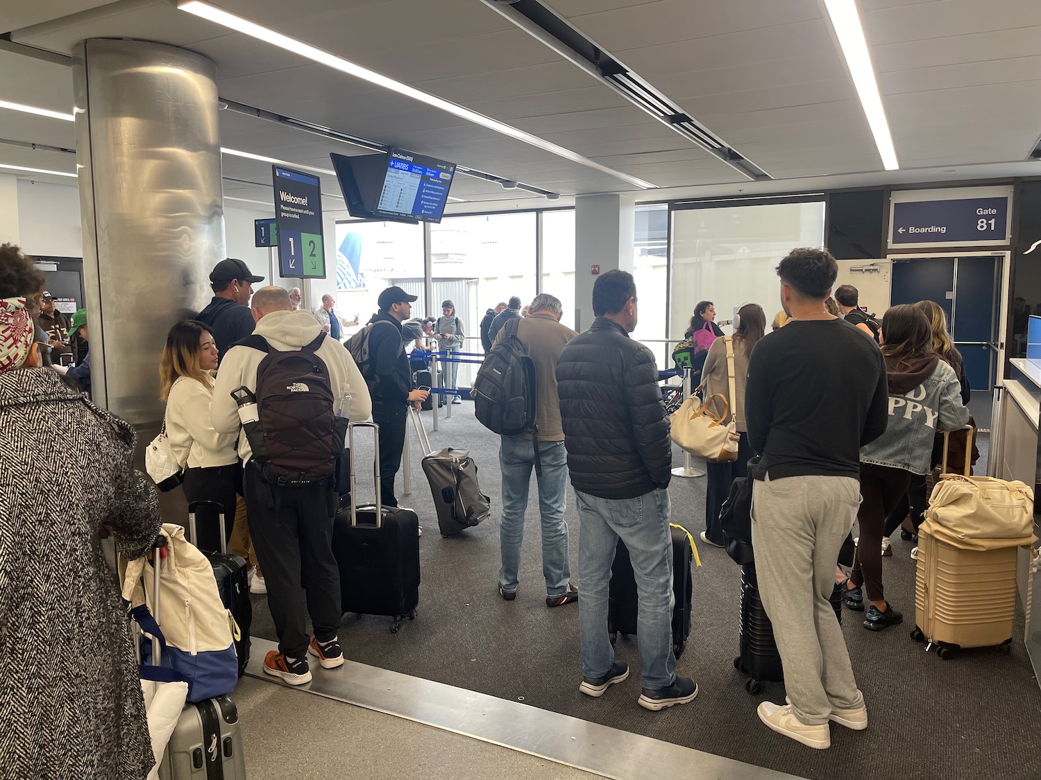 a group of people standing in a room with luggage