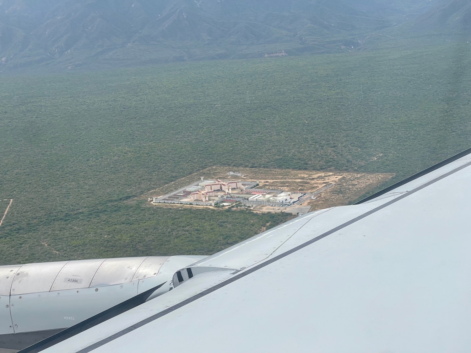 an airplane wing and a building in the distance