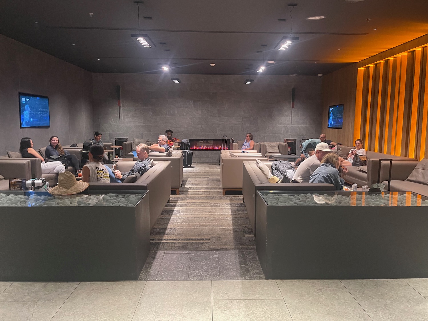 a group of people sitting in a room with a fireplace