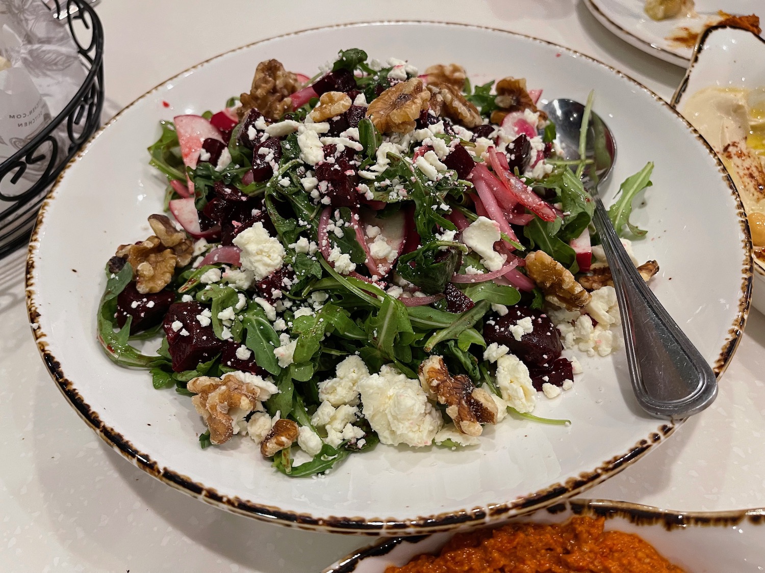 a plate of salad with a spoon