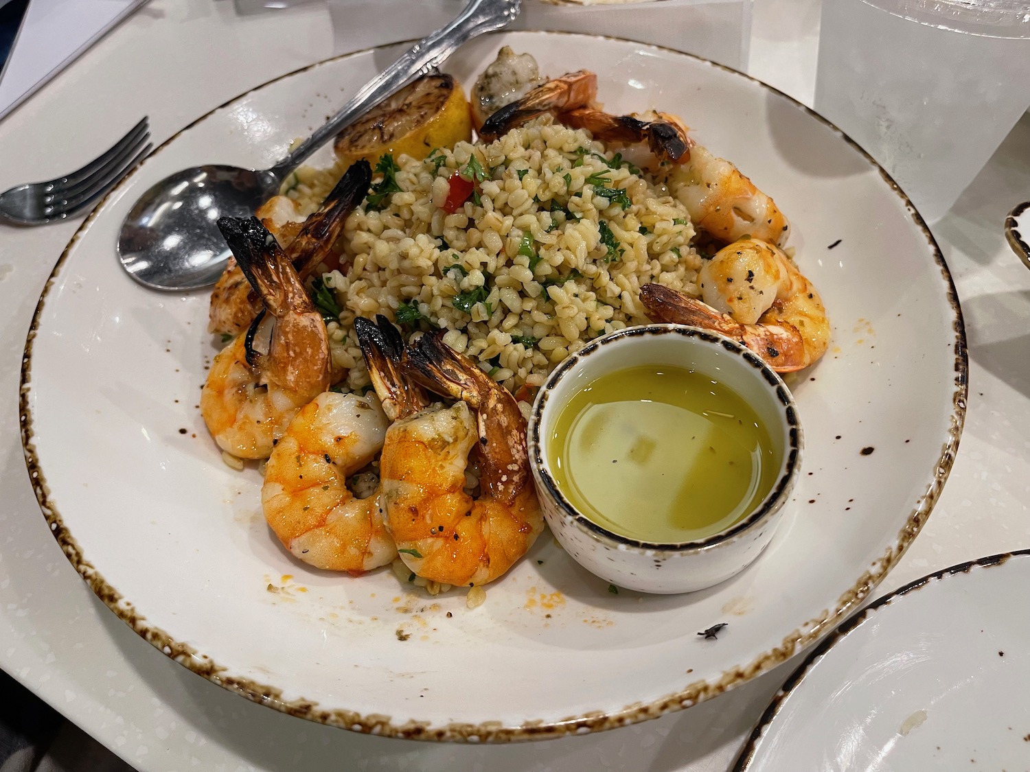 a plate of shrimp and rice with sauce