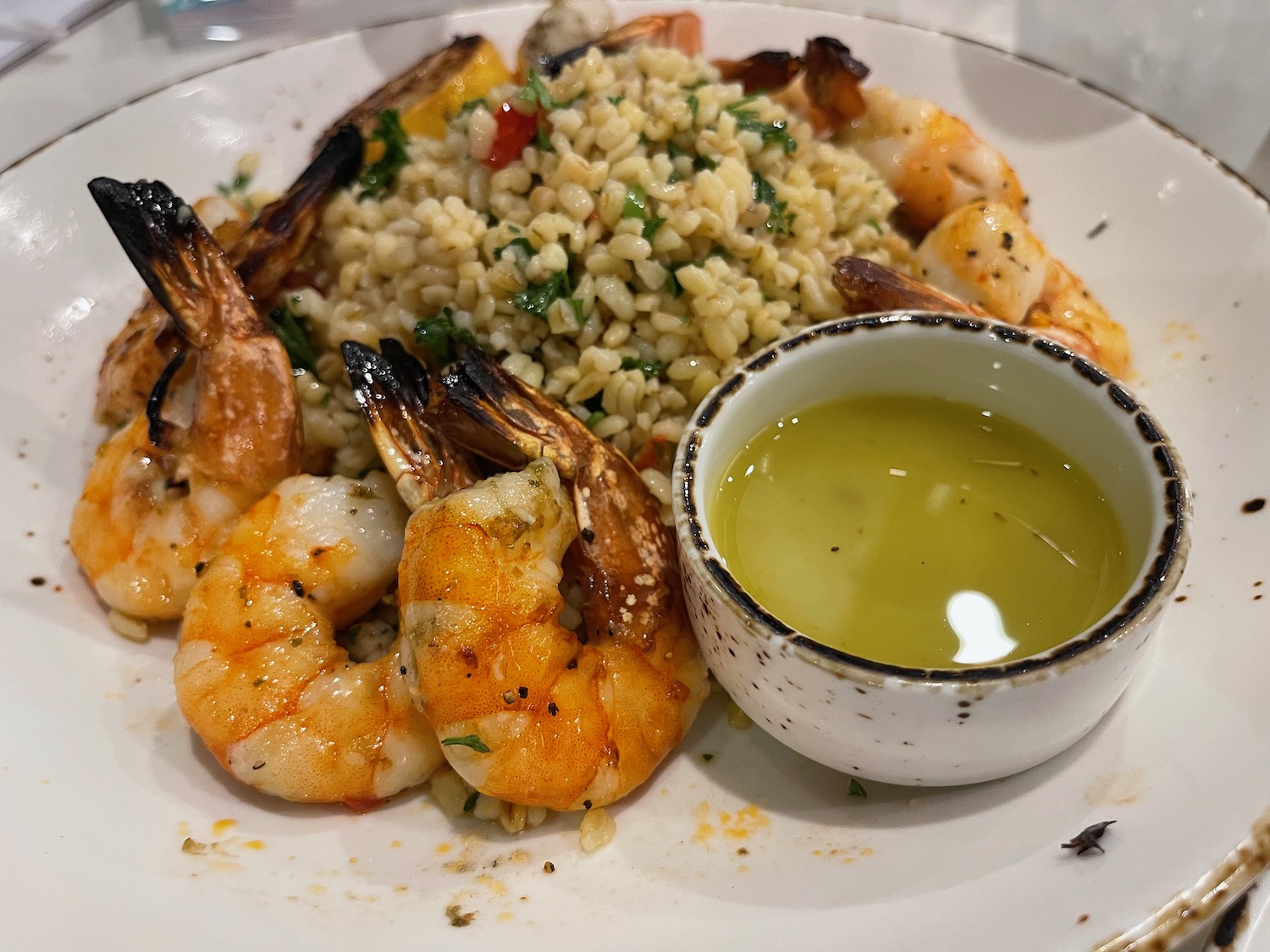 a plate of shrimp and rice with sauce