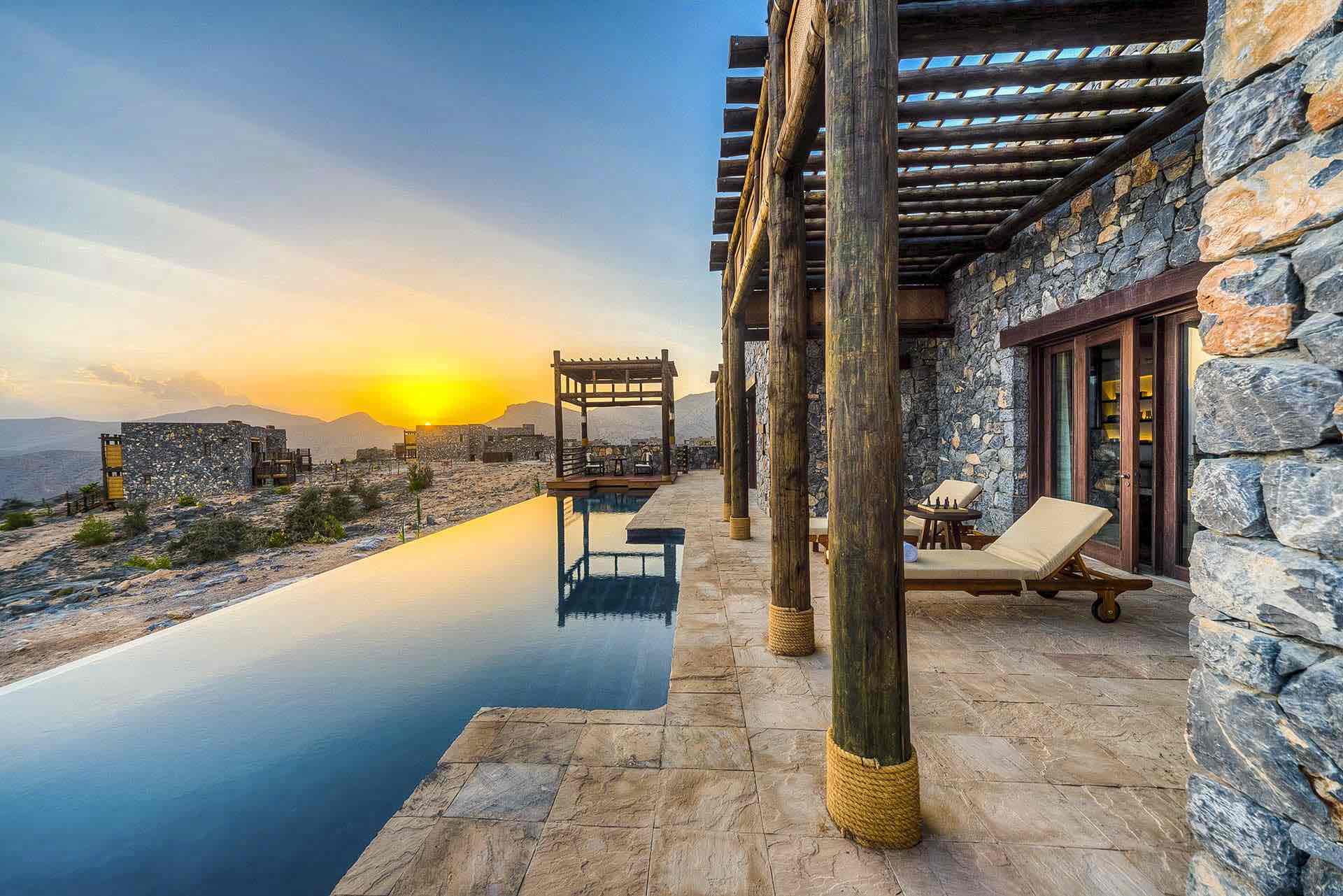 a pool with a deck and chairs on the side