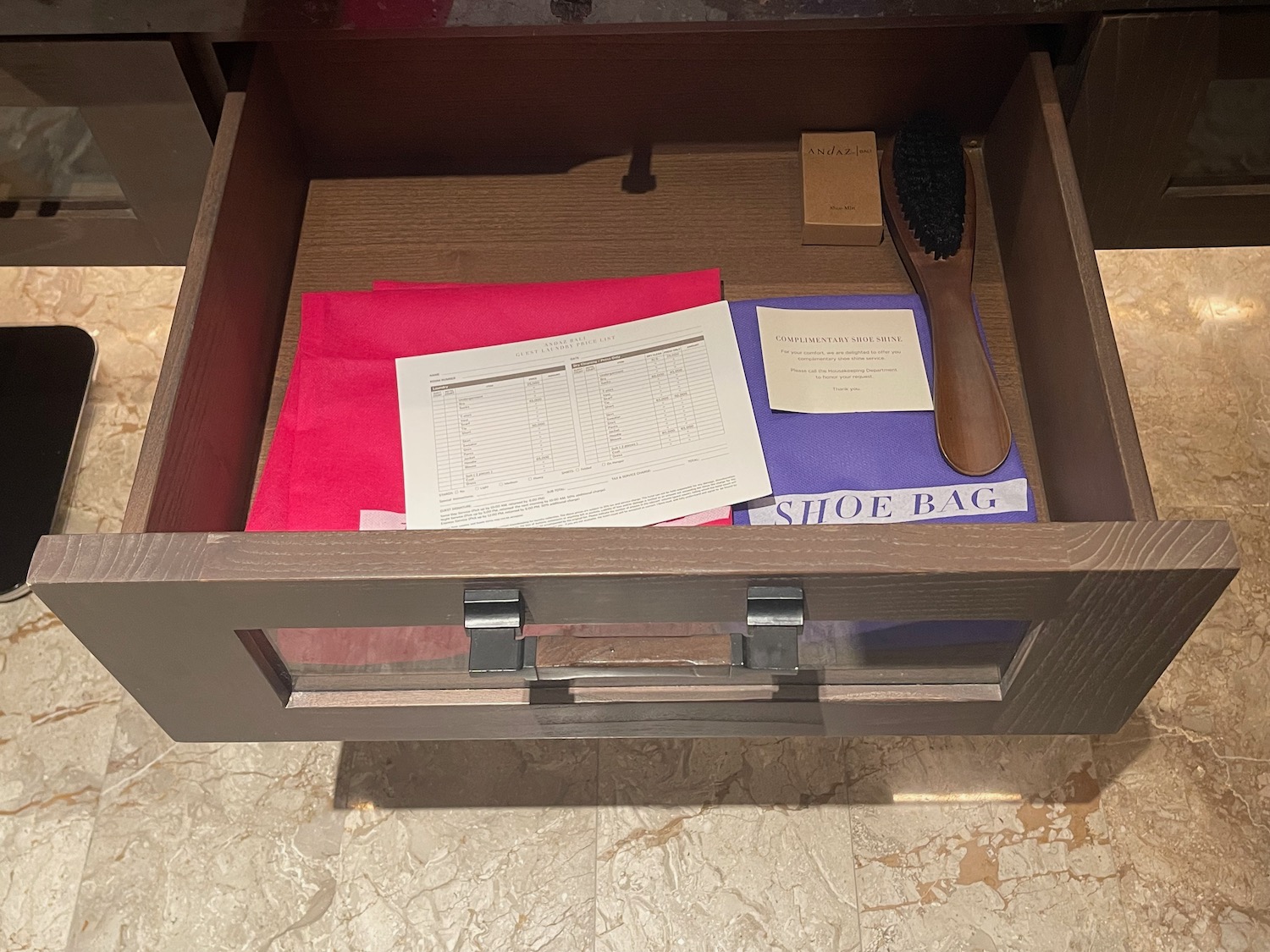 a drawer with papers and a brush