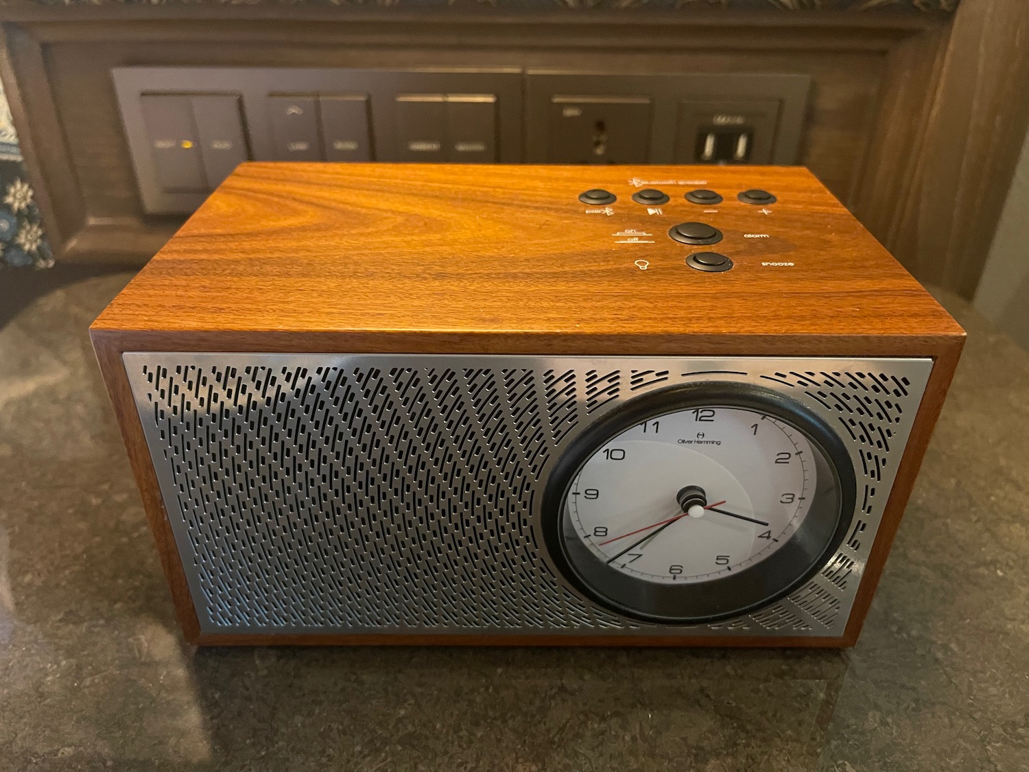 a wooden and silver radio with a clock on a counter