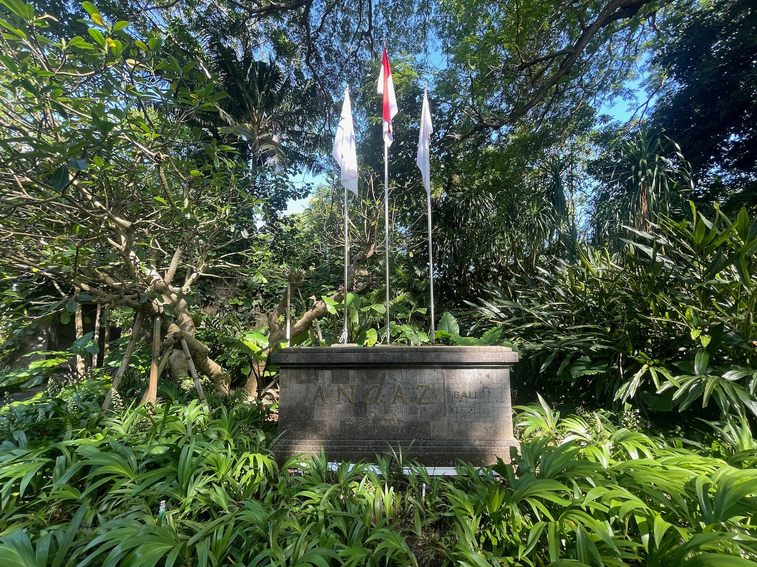 a stone monument with flags in the middle of a forest