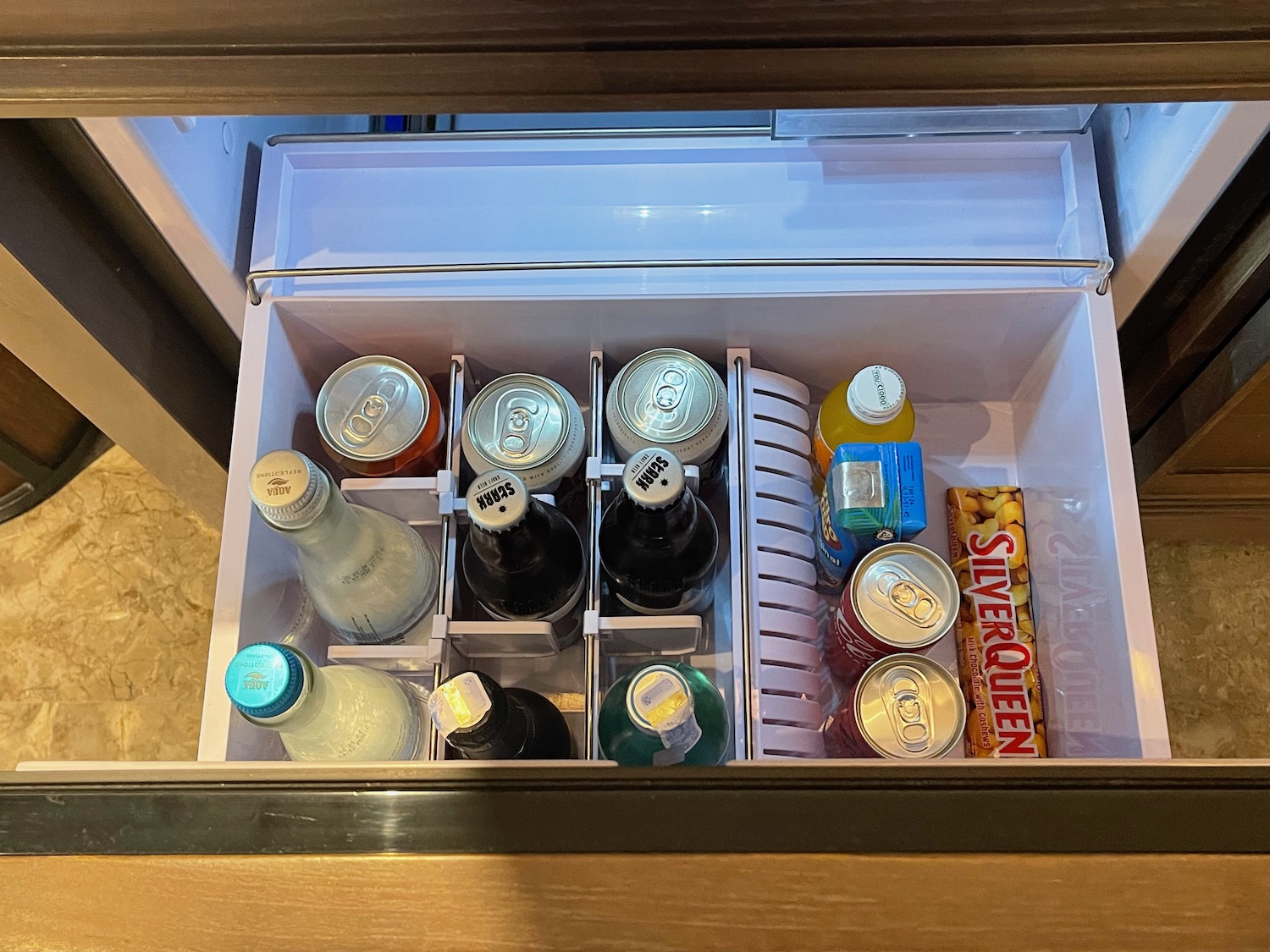 a refrigerator drawer with drinks and snacks