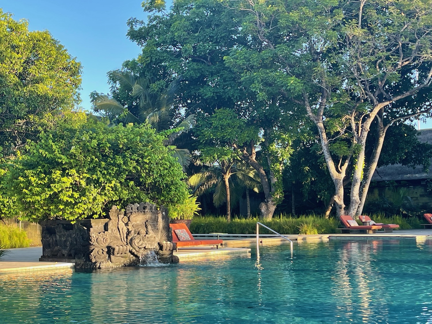 a pool with a fountain and trees