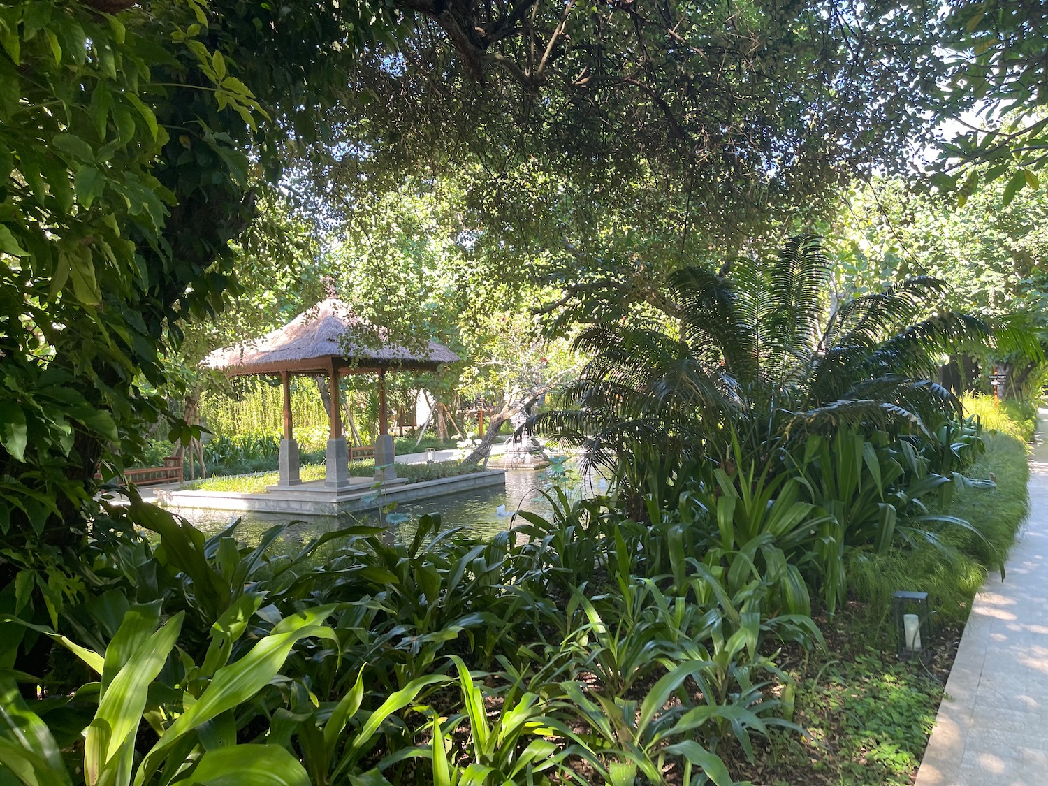 a gazebo next to a pond surrounded by trees