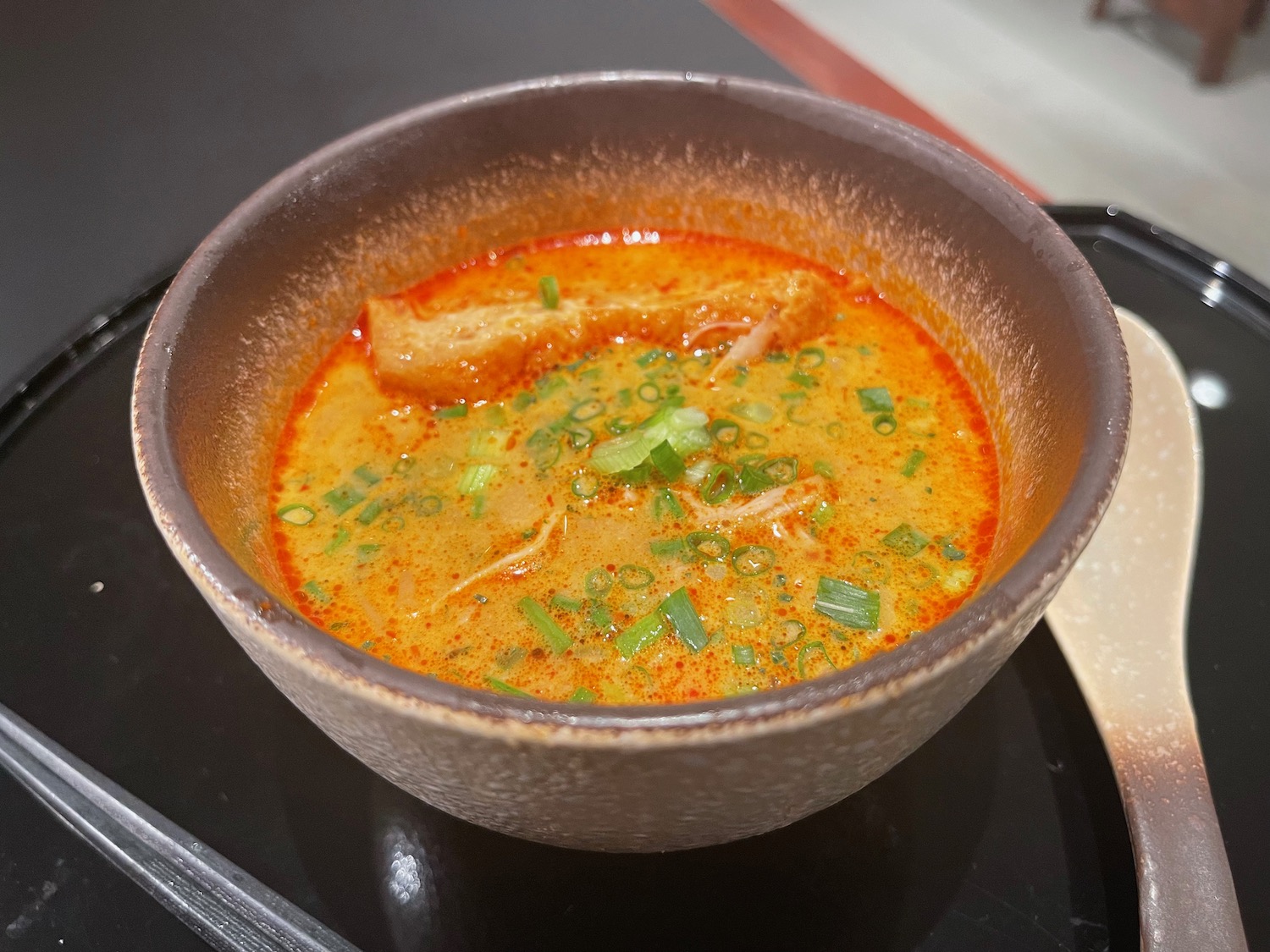 a bowl of soup on a black surface