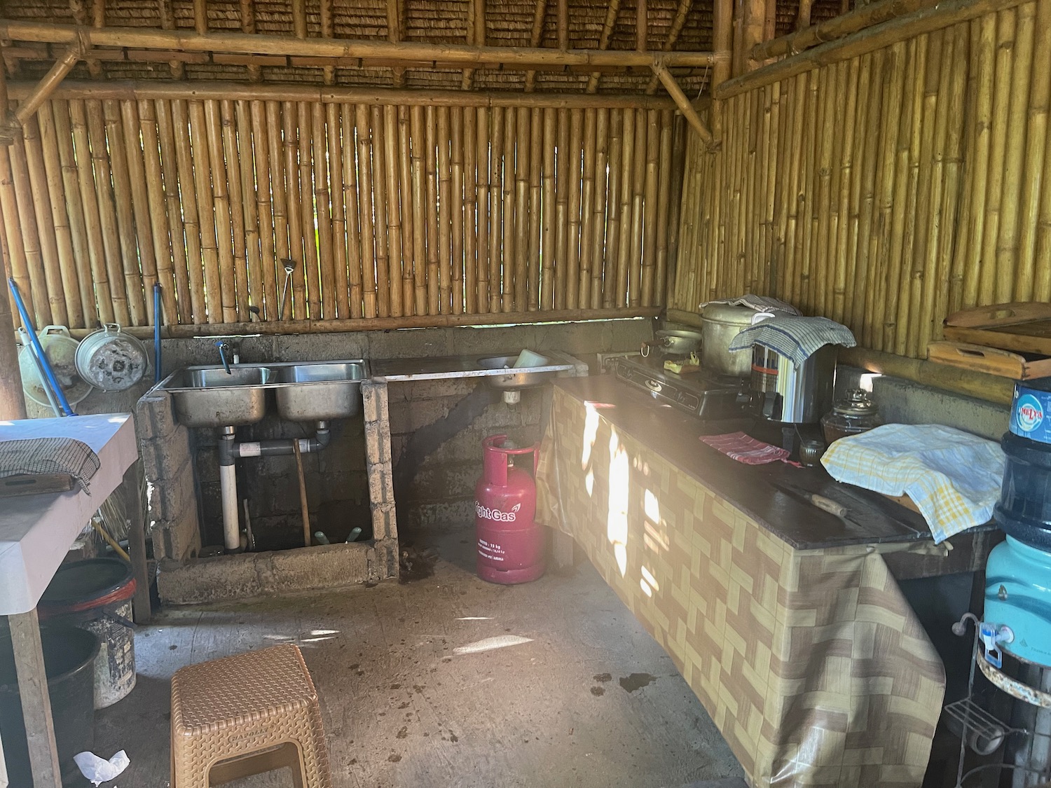 a kitchen with a sink and a red gas cylinder