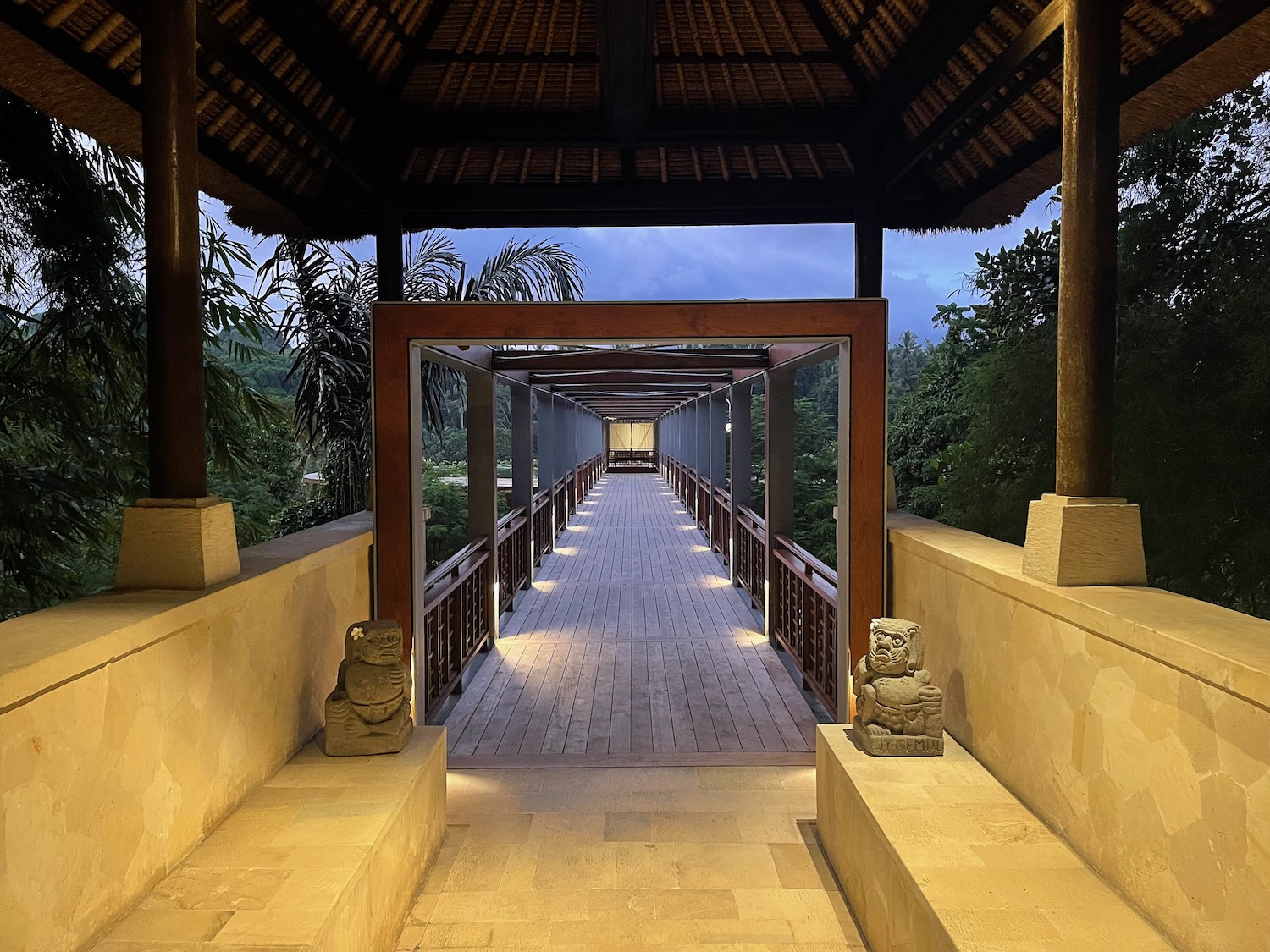 a walkway with a wooden structure and a wooden railing