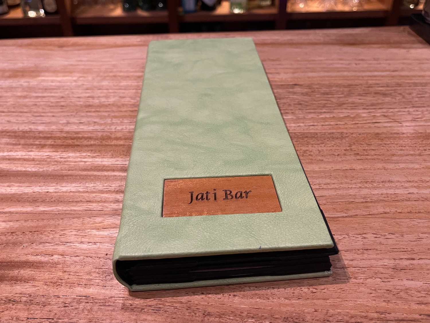 a green menu on a wood table