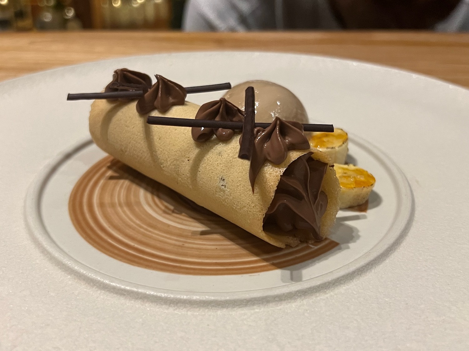 a crepe with chocolate frosting and ice cream on a plate