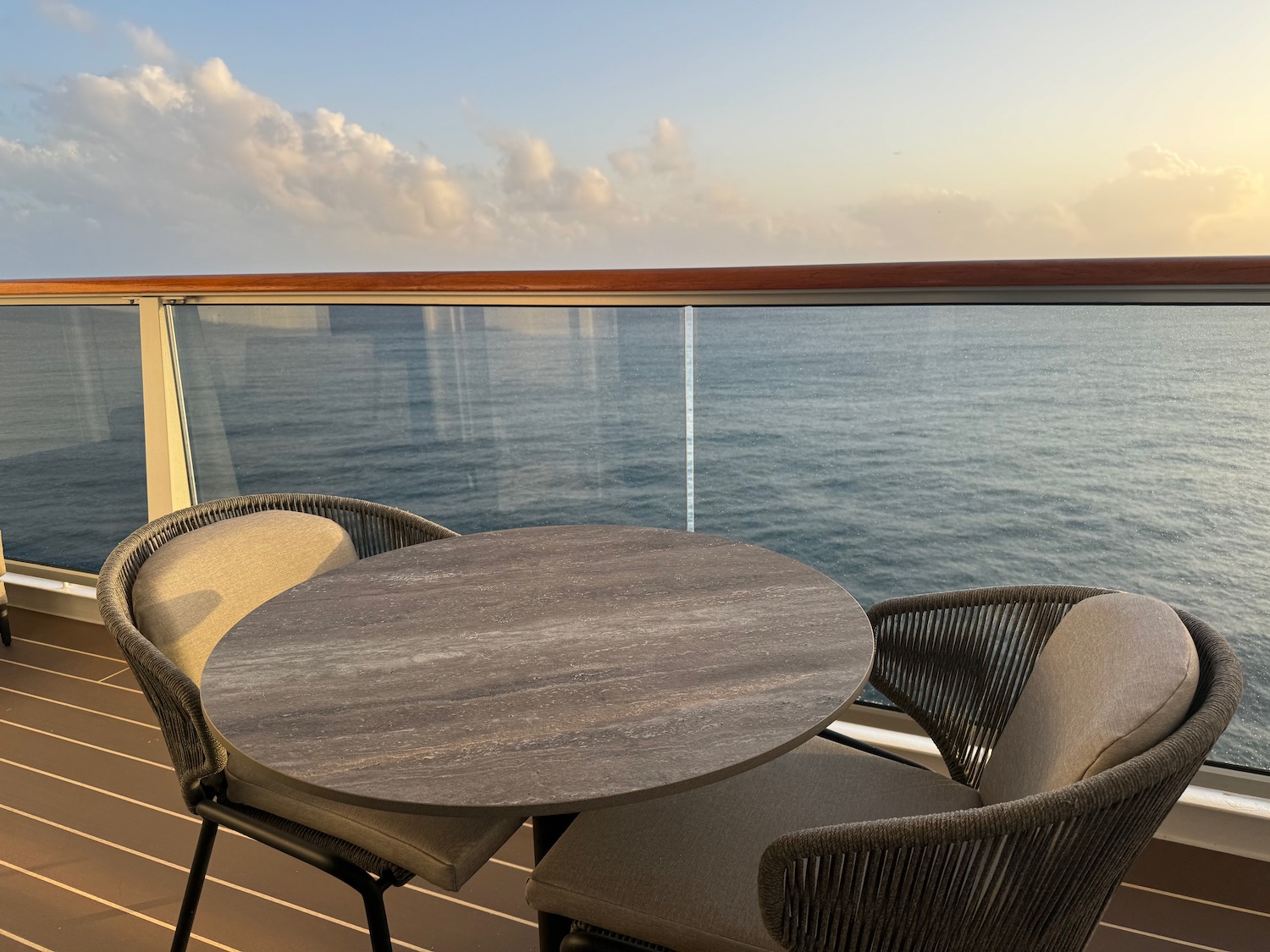 a table and chairs on a deck overlooking the ocean