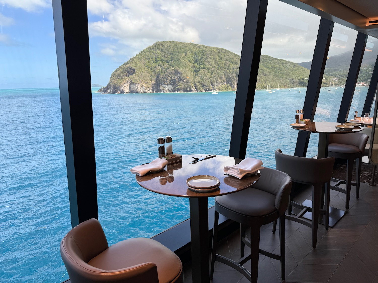 a table and chairs with a view of the ocean