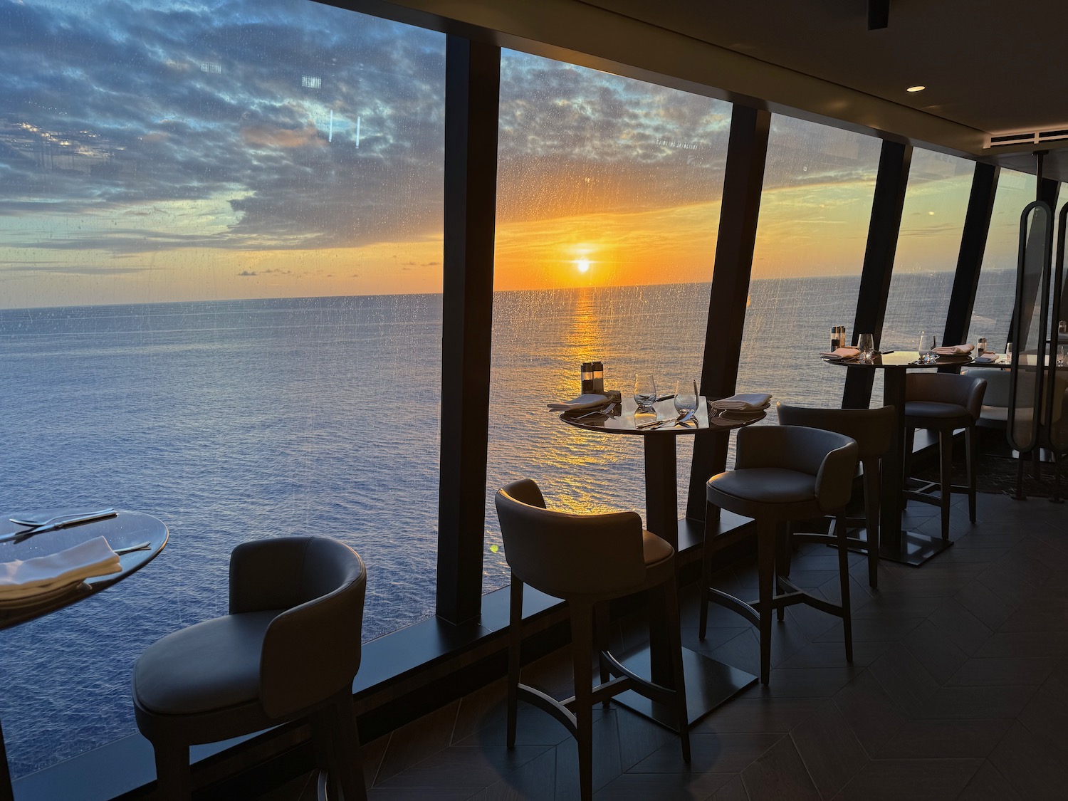 a restaurant with tables and chairs overlooking the ocean