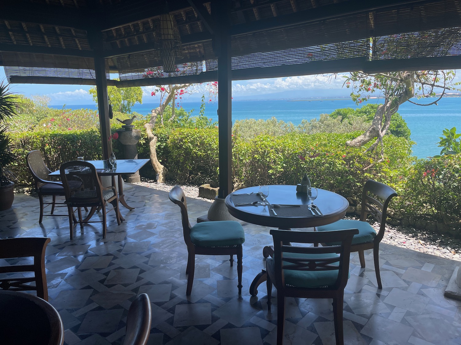 a table and chairs outside with a view of the ocean