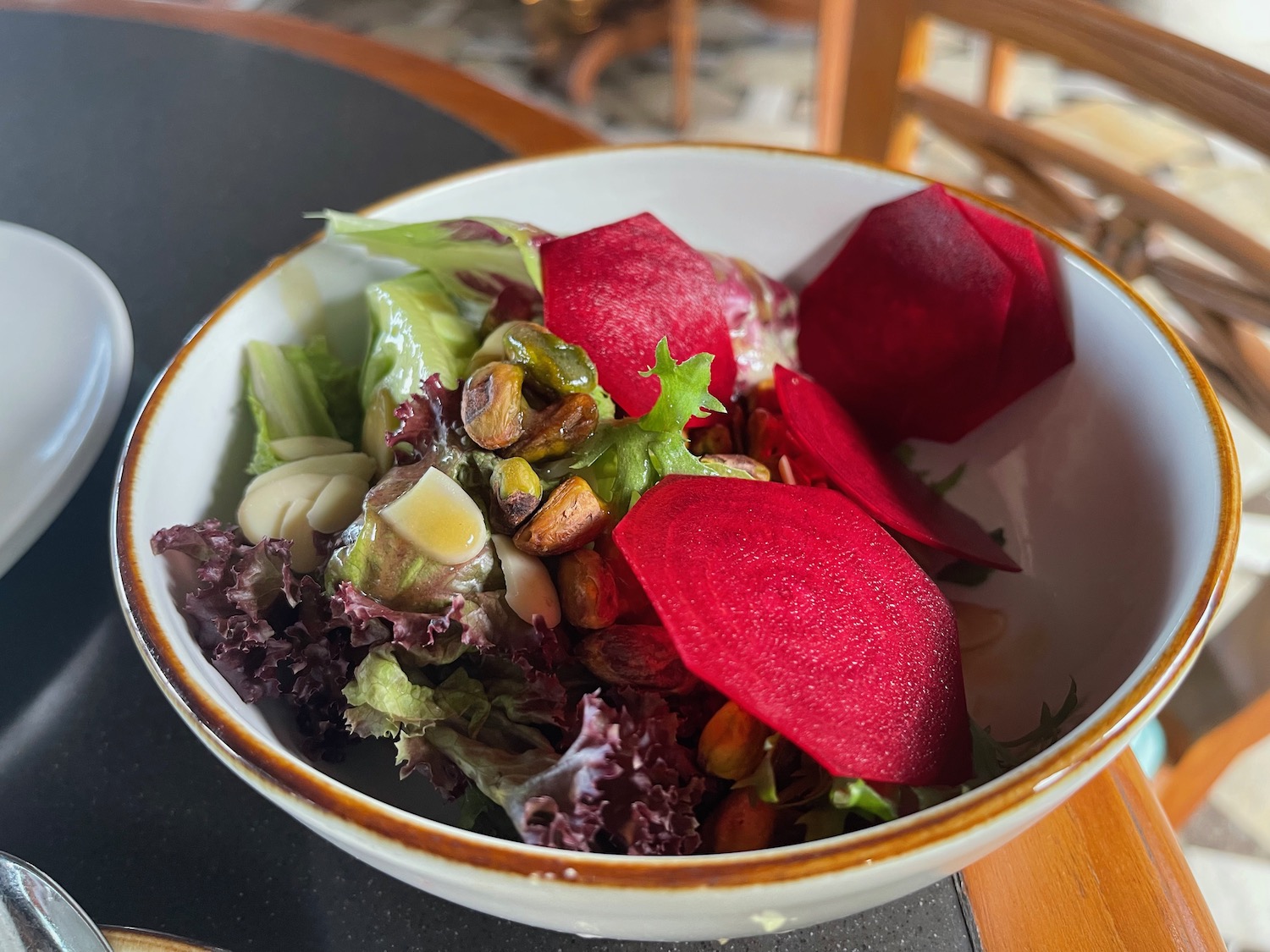 a bowl of salad with beets and nuts
