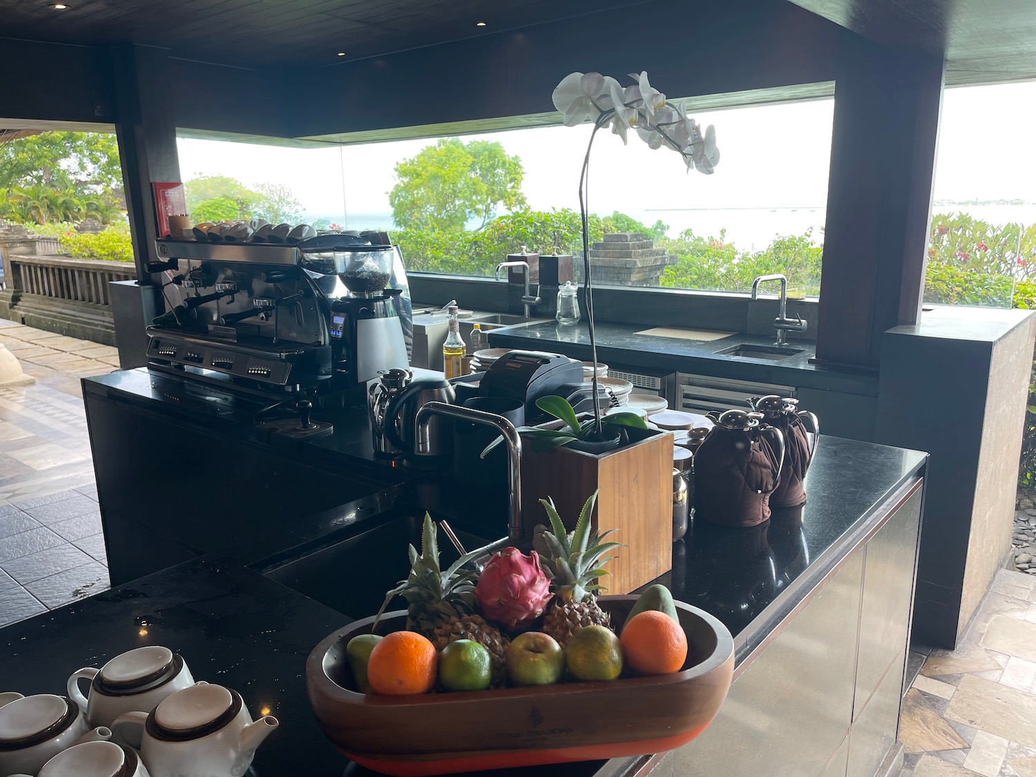 a counter with a bowl of fruit and a coffee machine